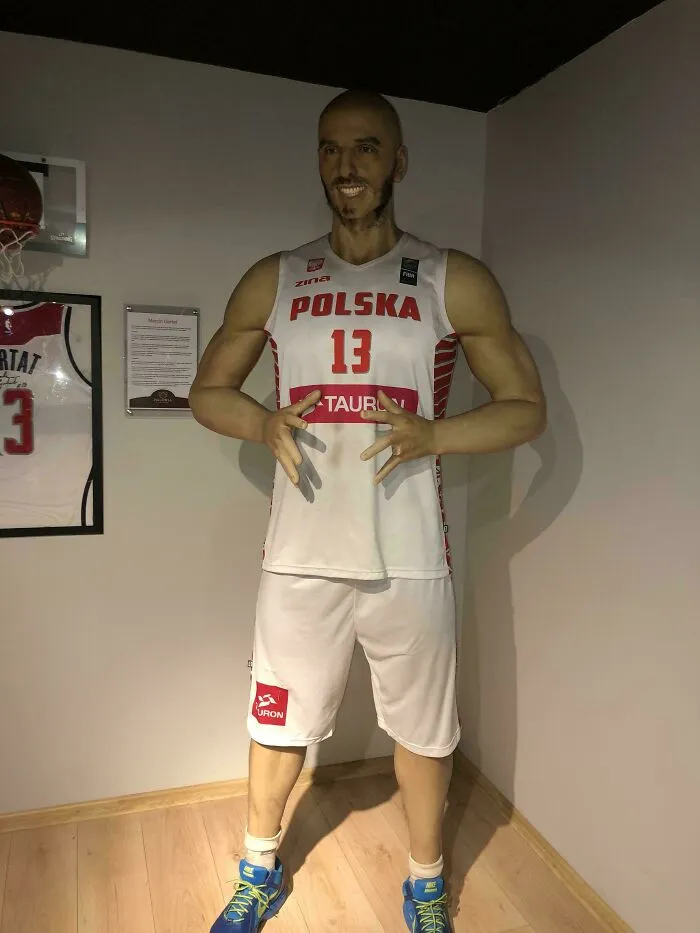 Celebrity wax figure in Polish basketball uniform with number 13 posing indoors