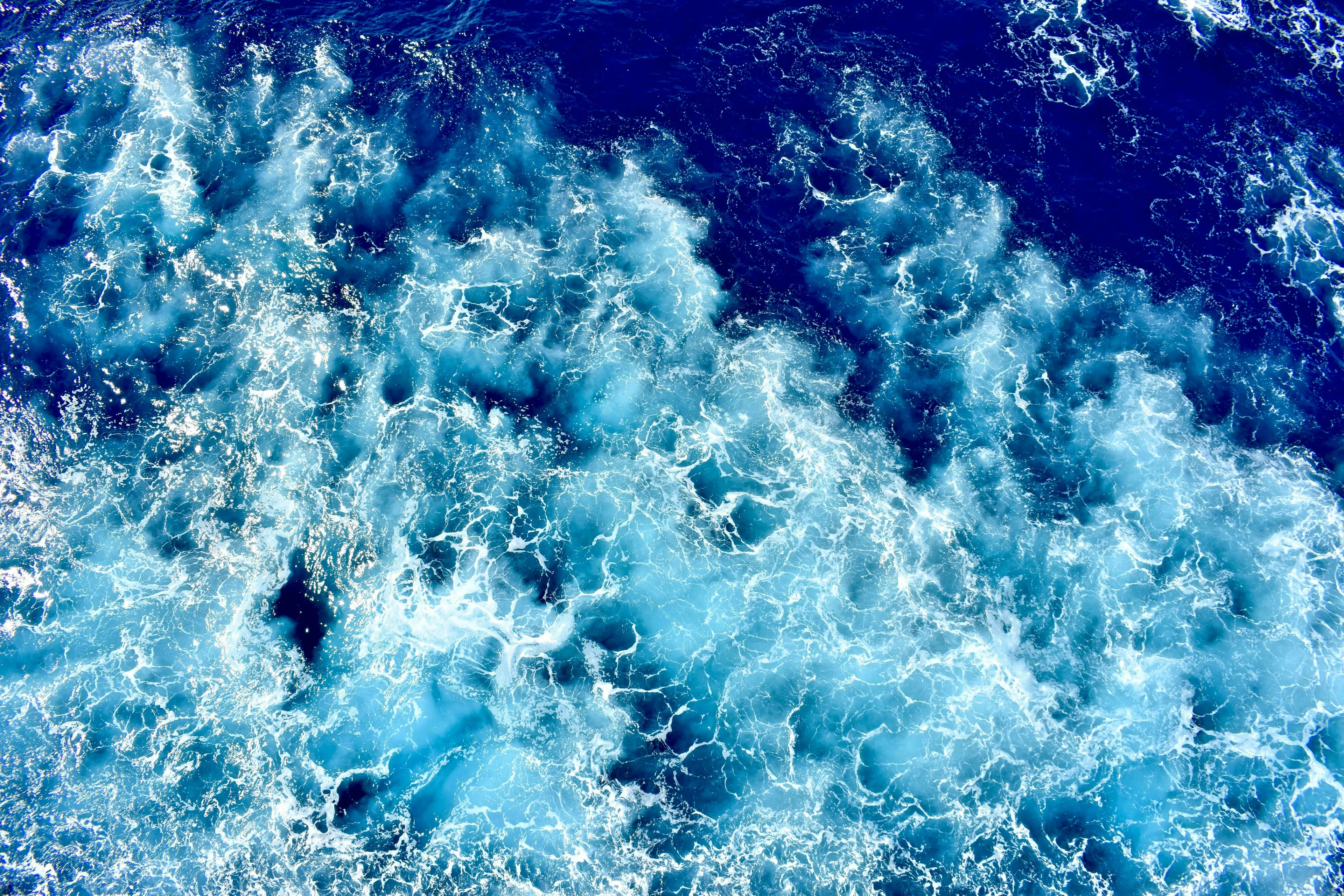 A General Knowledge Quiz image of deep blue ocean water with swirling white foam and lighter blue currents.
