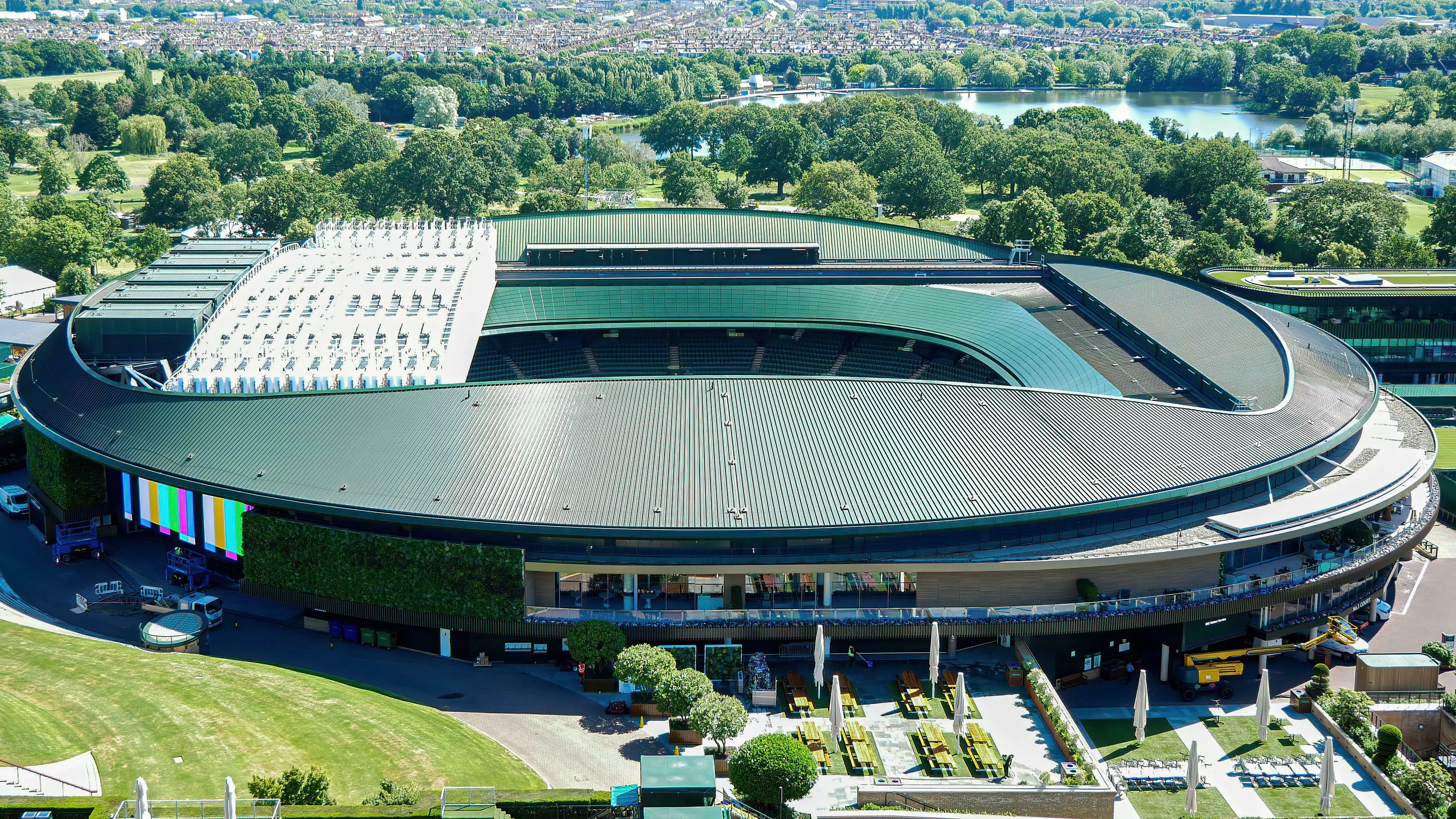 Aerial view of Wimbledon Championships tennis stadium, lush green roof and surrounding parkland, perfect for a general knowledge quiz.