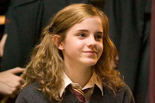 A young Hermione Granger, with wavy brown hair and a slight smile, wearing a Hogwarts uniform. She'd be a great friend.