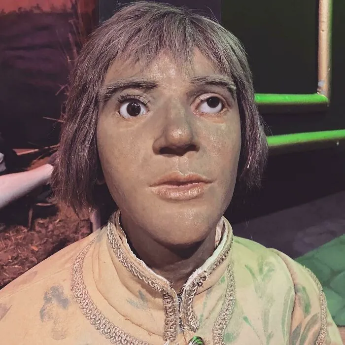 Distorted celebrity wax figure with mismatched eyes and detailed costume