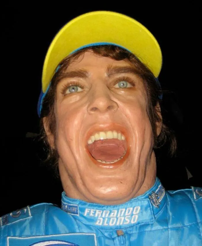 Close-up of poorly made Fernando Alonso celebrity wax figure with yellow cap