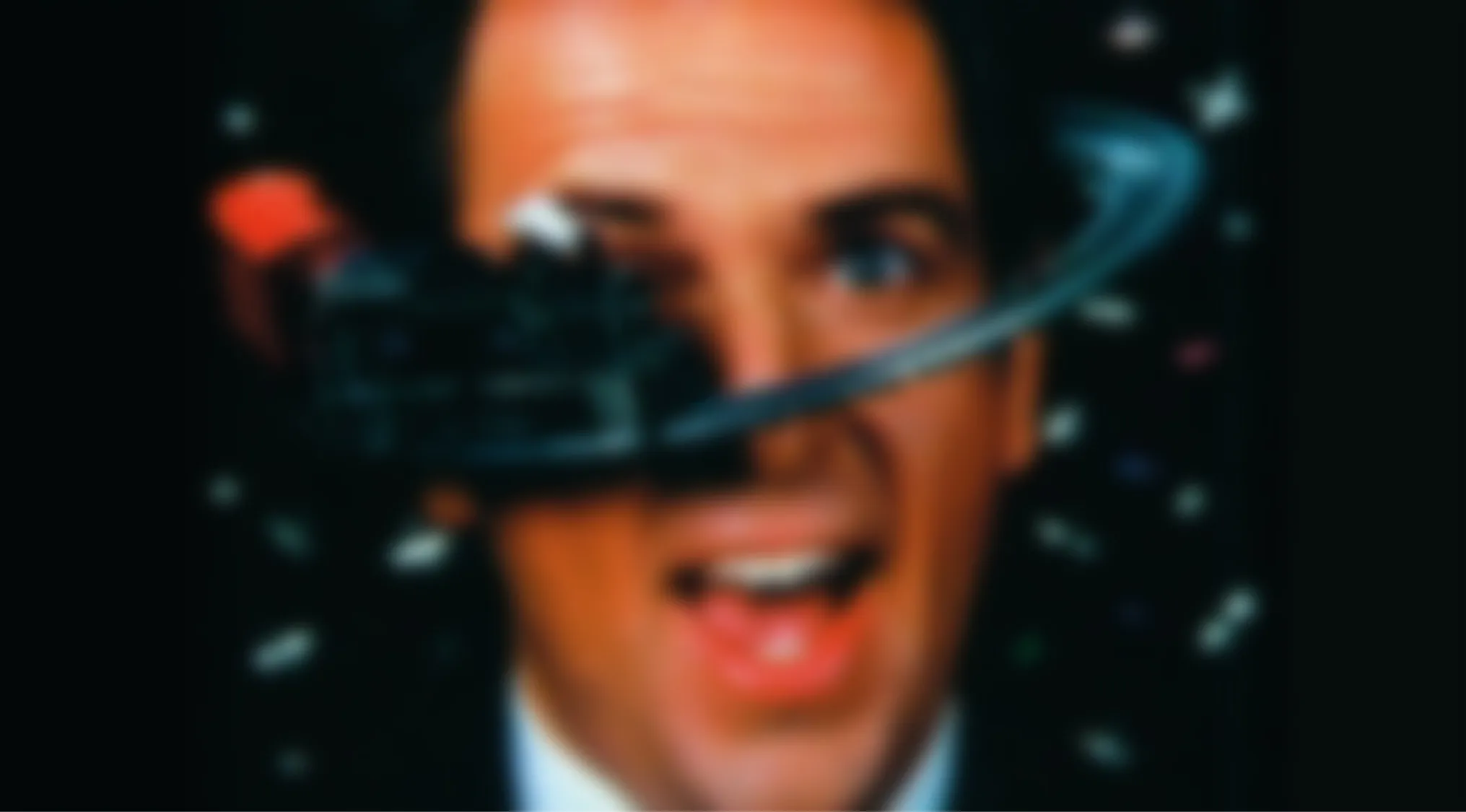 A blurry image of a man's face, with a record player needle spinning over his eye. Perfect for a Blurry Music Videos Quiz!