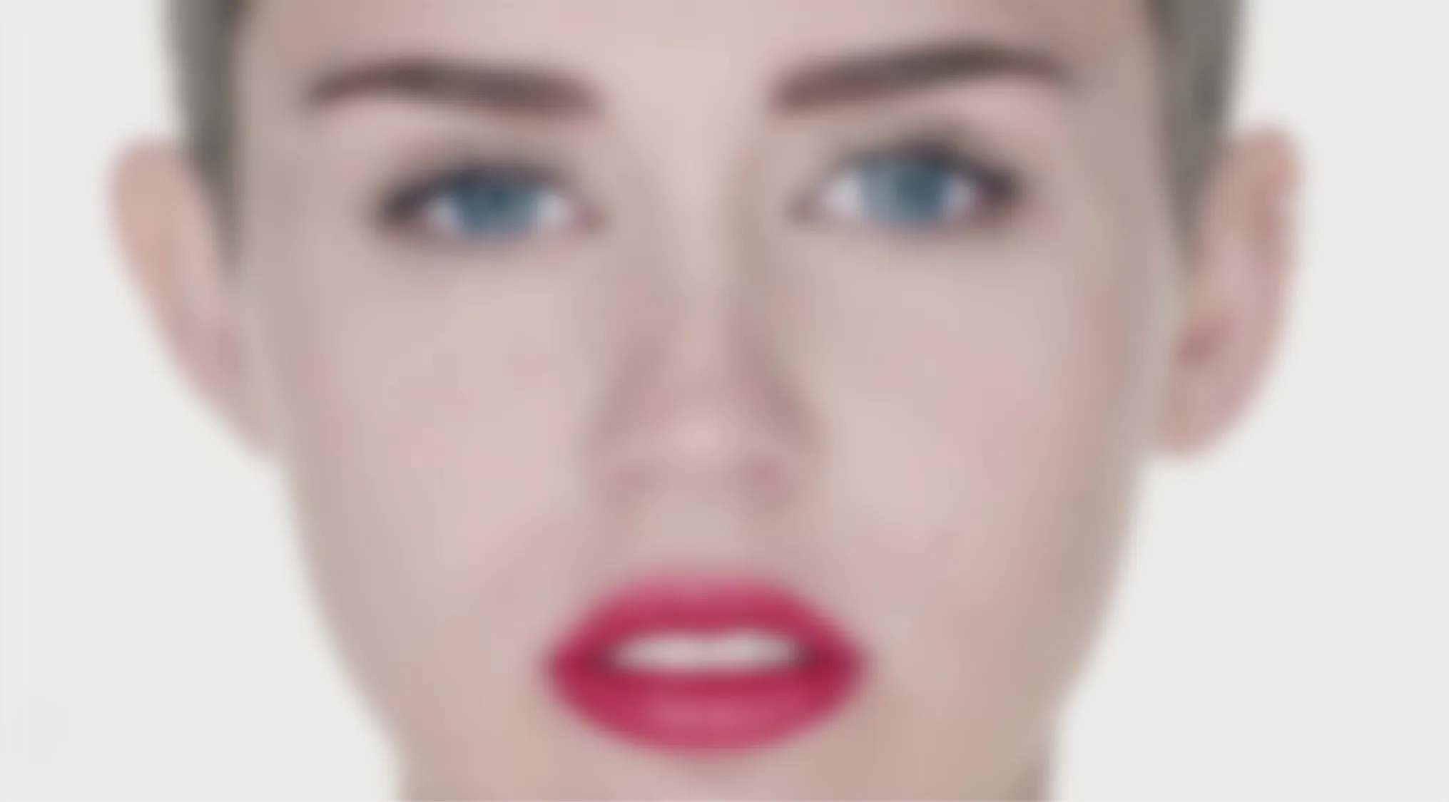 A blurry image of a woman's face with bright blue eyes and vibrant red lipstick for a Blurry Music Videos Quiz.