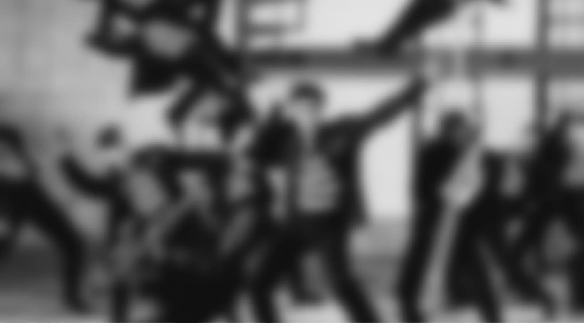 Black and white image of blurry figures dancing, a Blurry Music Videos Quiz challenge for fans to guess the clip.