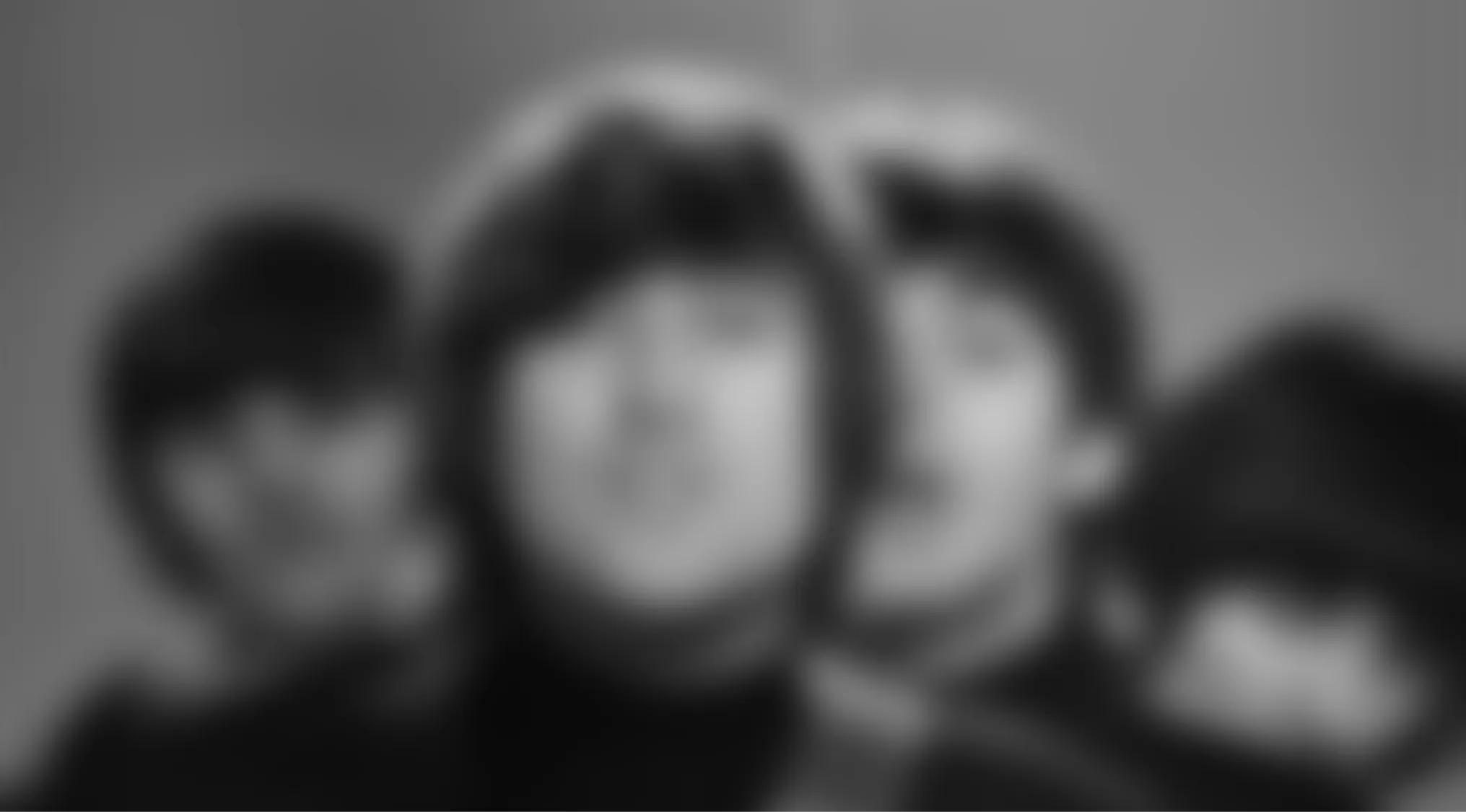 Blurry music videos quiz: A black and white blurry image of four people in close-up, possibly a band.