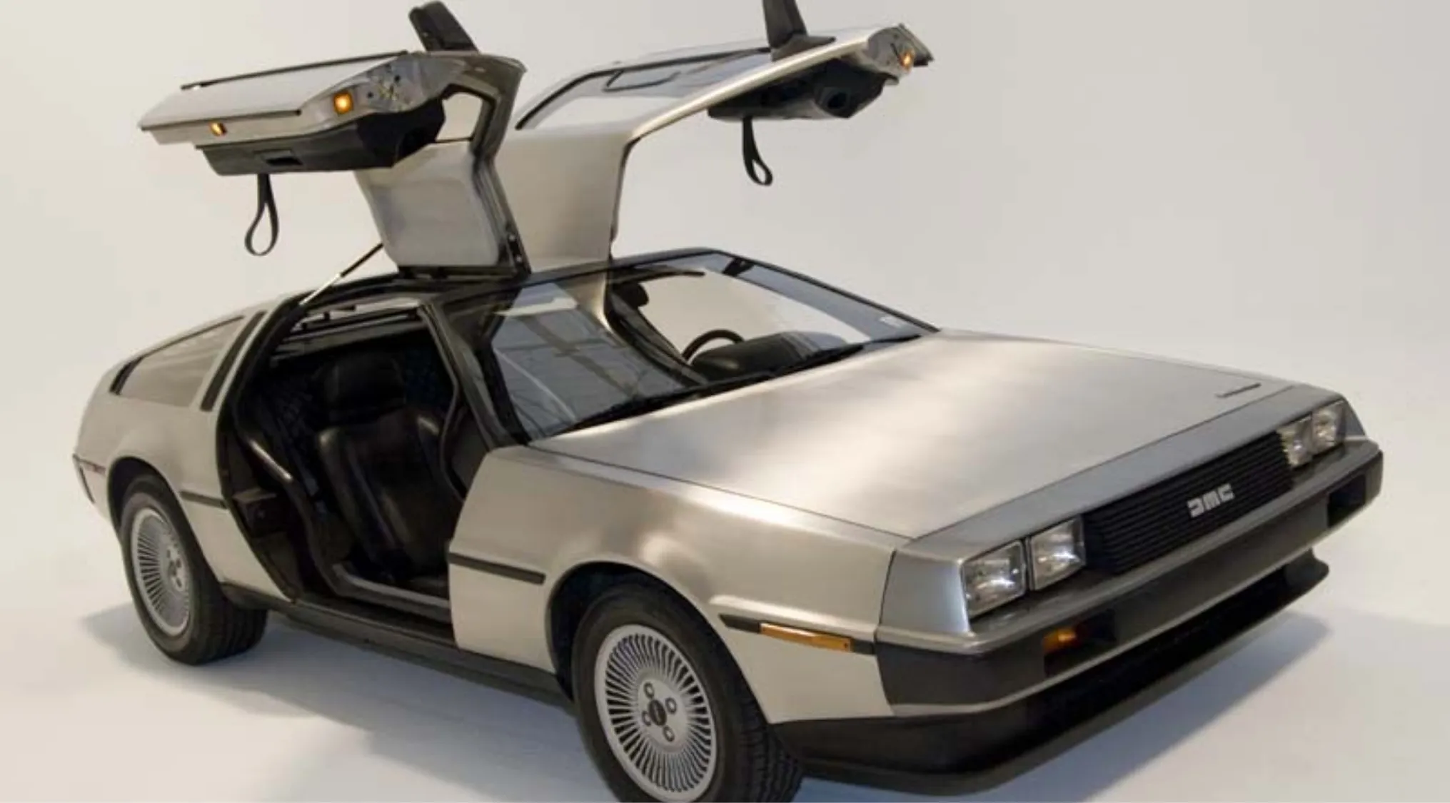 The iconic DeLorean car with its gull-wing doors open, a symbol of 80s pop culture time-travel films.