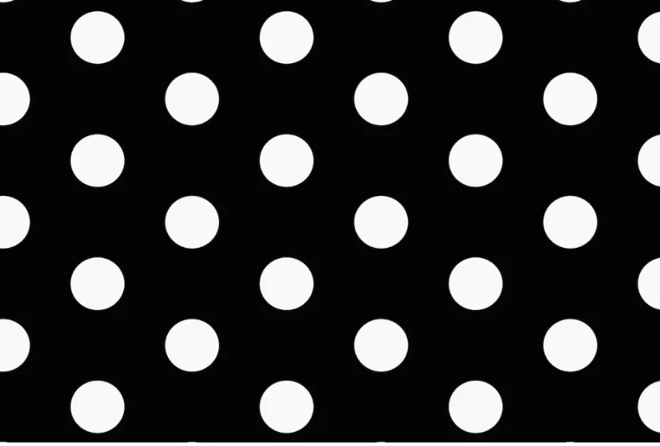 A close-up of a vibrant Polka Dots pattern on a black fabric, a style popularized by Vivienne Westwood.