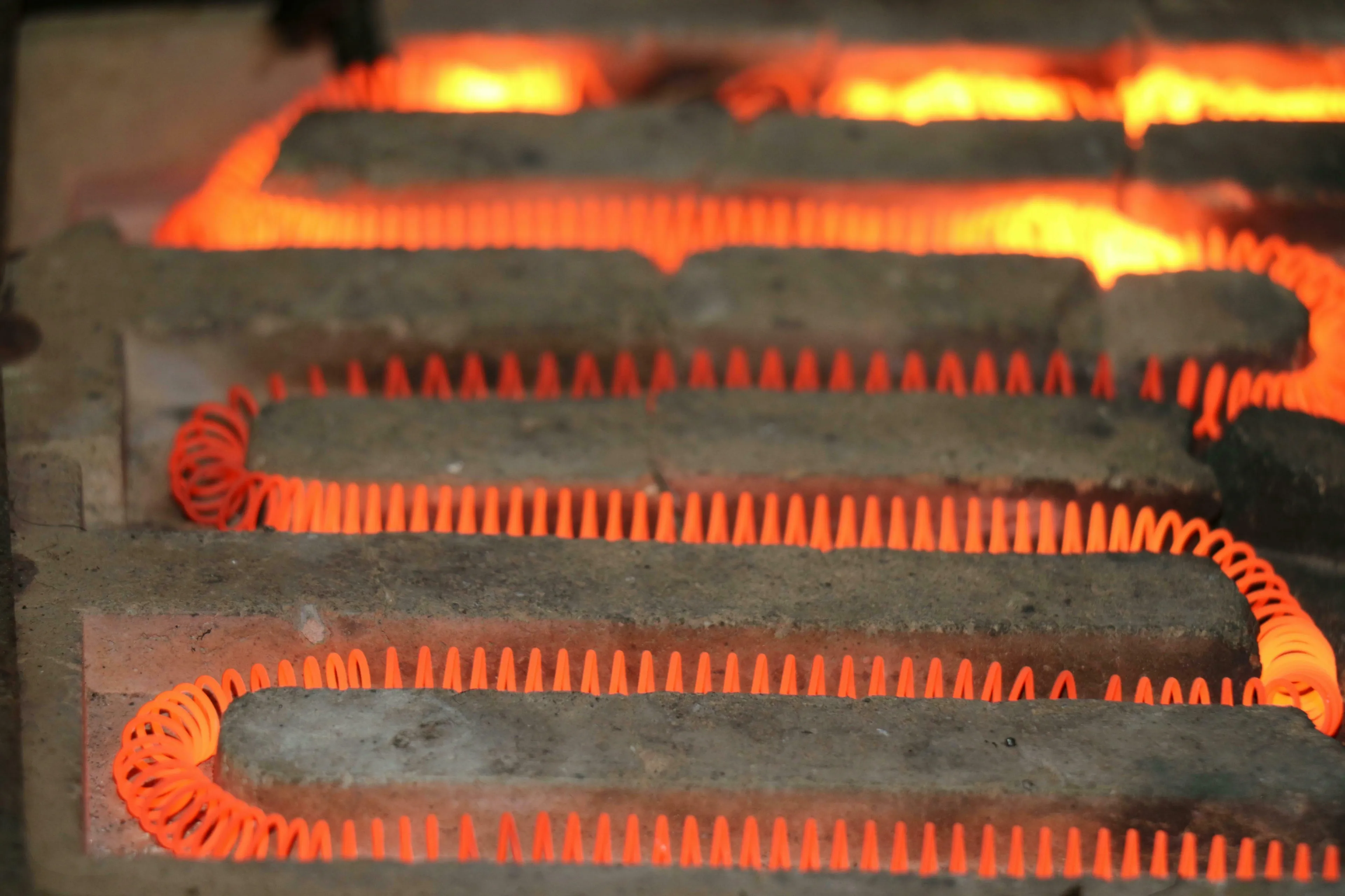 Glowing orange heating elements in a furnace, demonstrating the principle of conduction for a science general knowledge quiz.