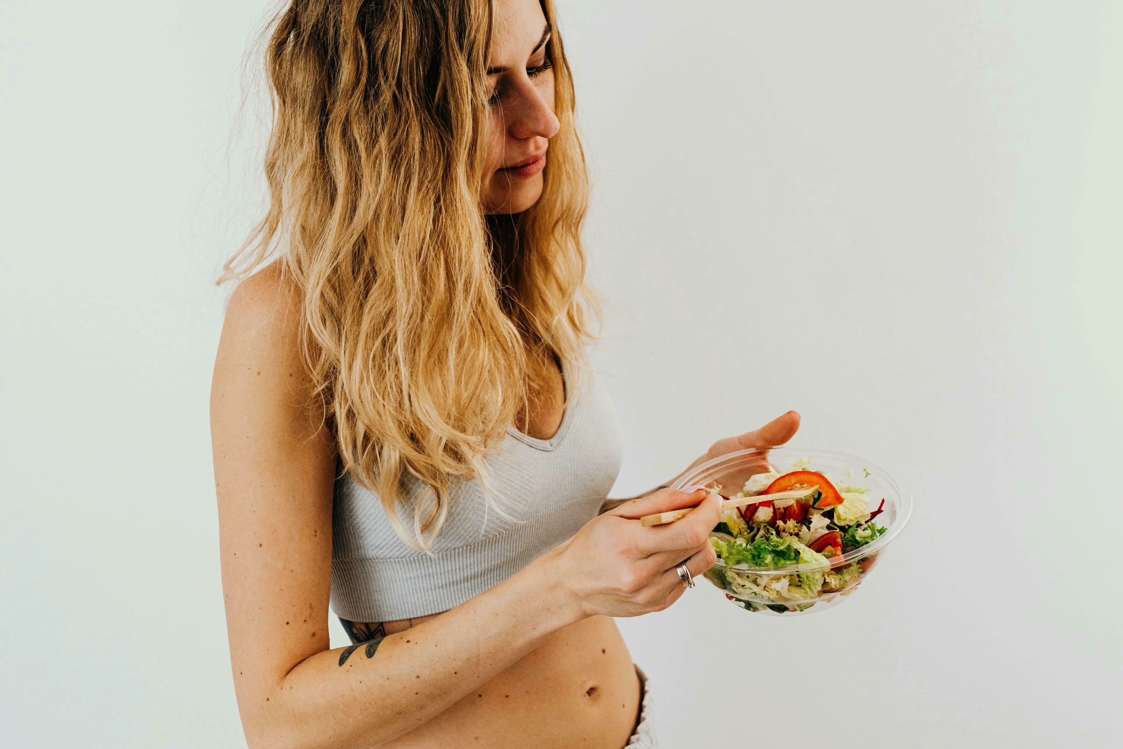 Woman eating a healthy salad. Science general knowledge on catalysts in the digestive system.