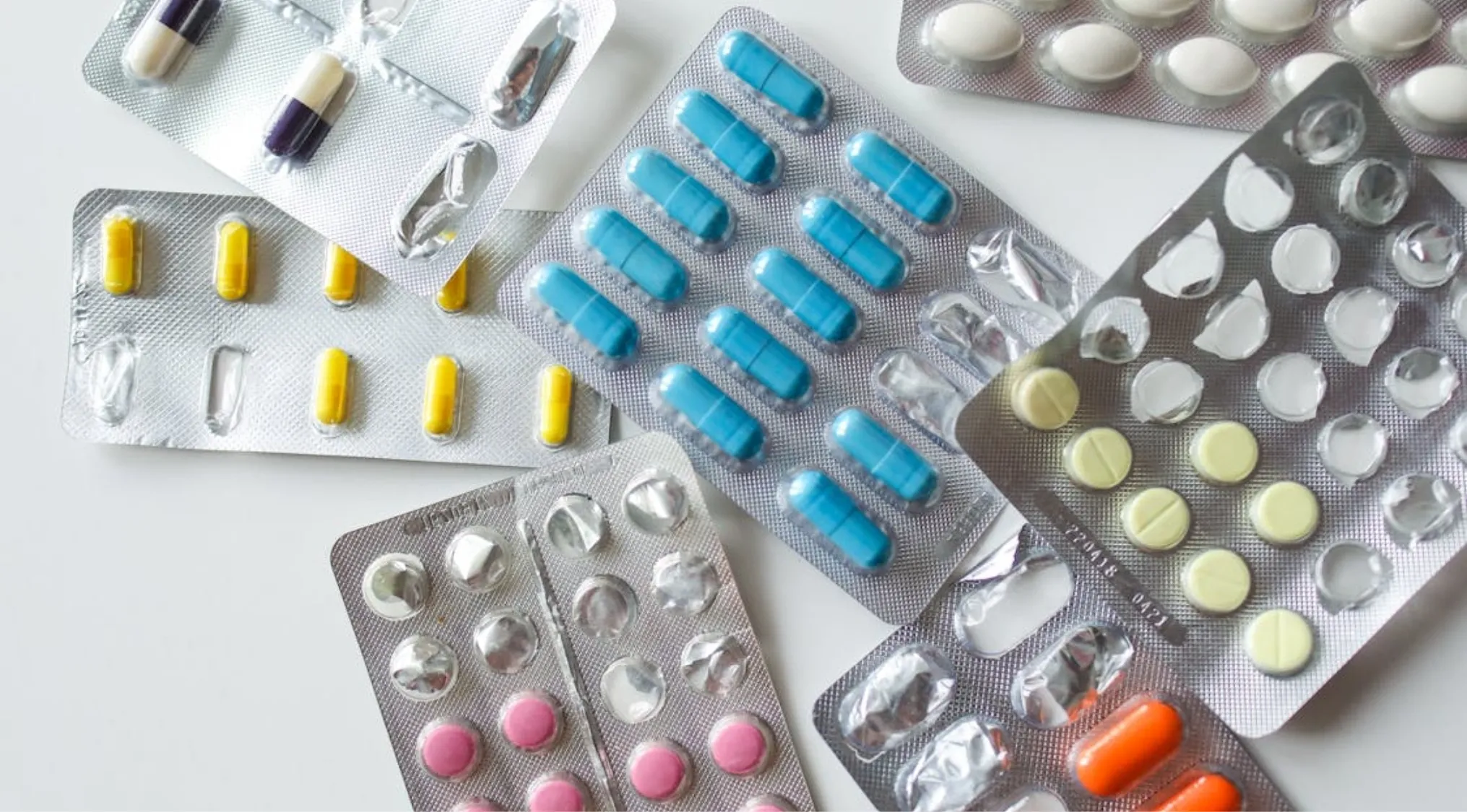 Various blister packs of medications. Some are full, others partially used, highlighting First Aid for survival.