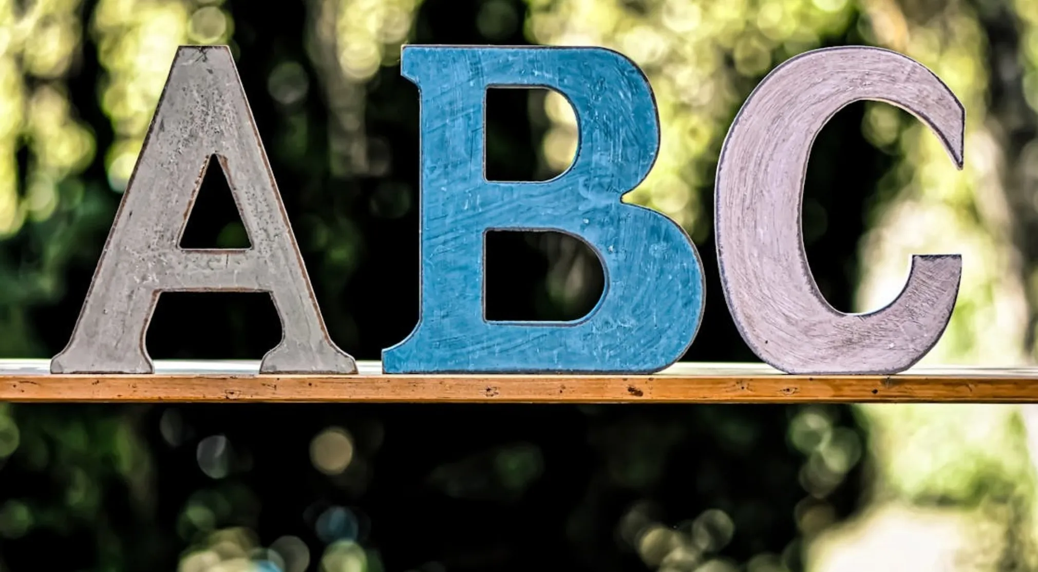 Wooden letters A, B, and C on a shelf. Represents ABCs of First Aid: Survival 101.