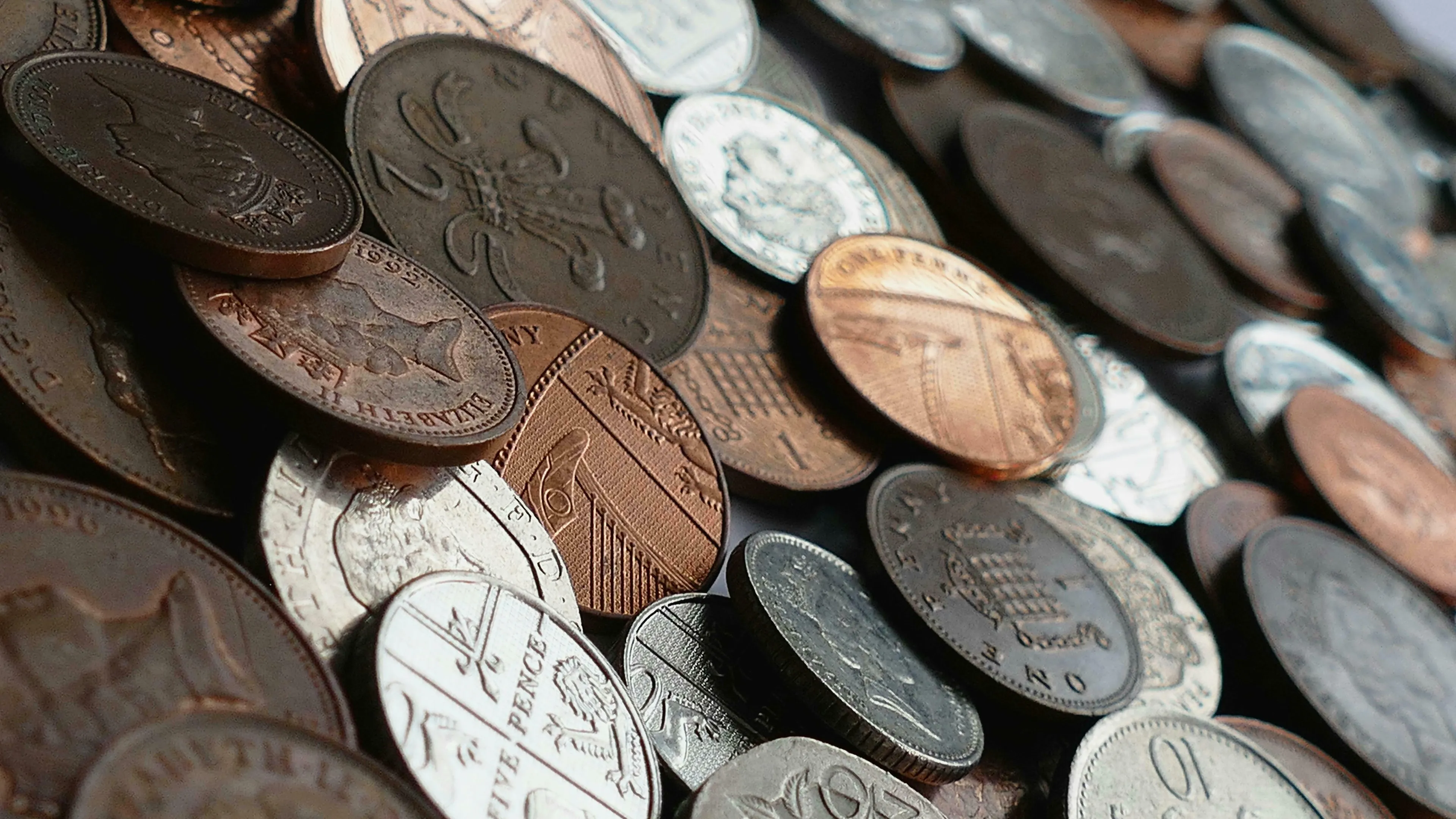 A close-up of various British coins, including pennies and pence, for a vocabulary quiz about UK slang.