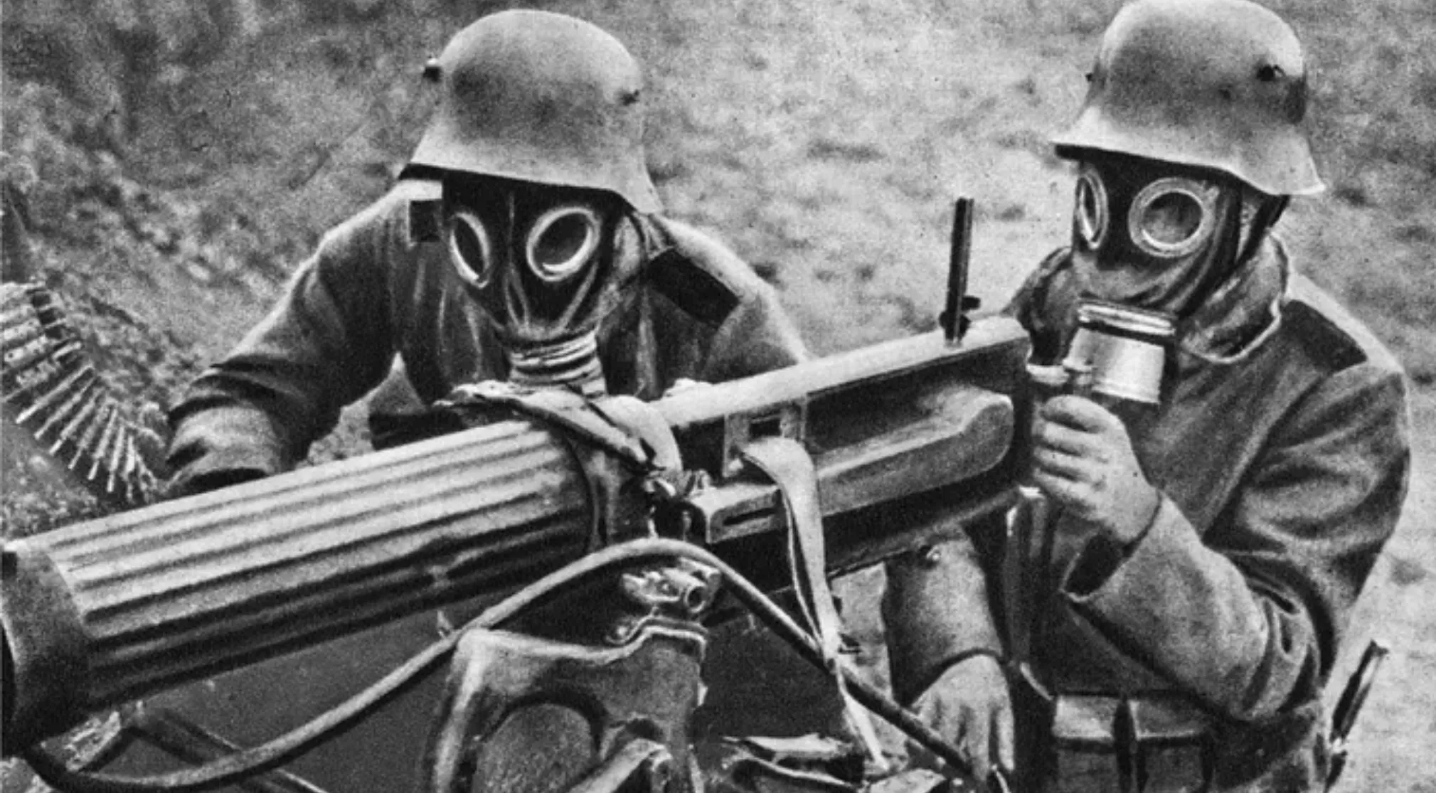 Two WWI soldiers in gas masks operating a machine gun, highlighting the intensity of WWI.