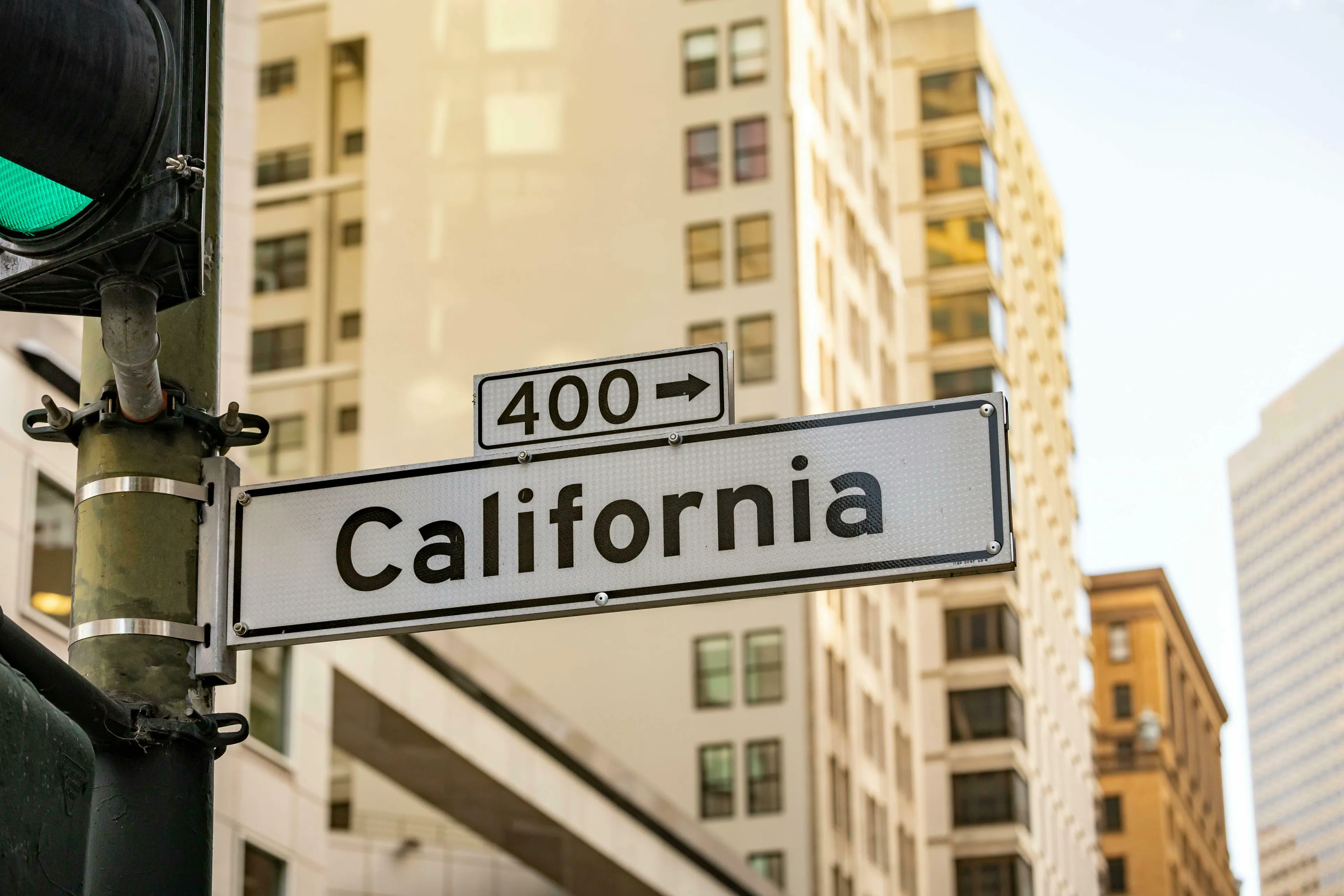 A California street sign with a 400 directional arrow against a backdrop of tall city buildings. US state capitals quiz.