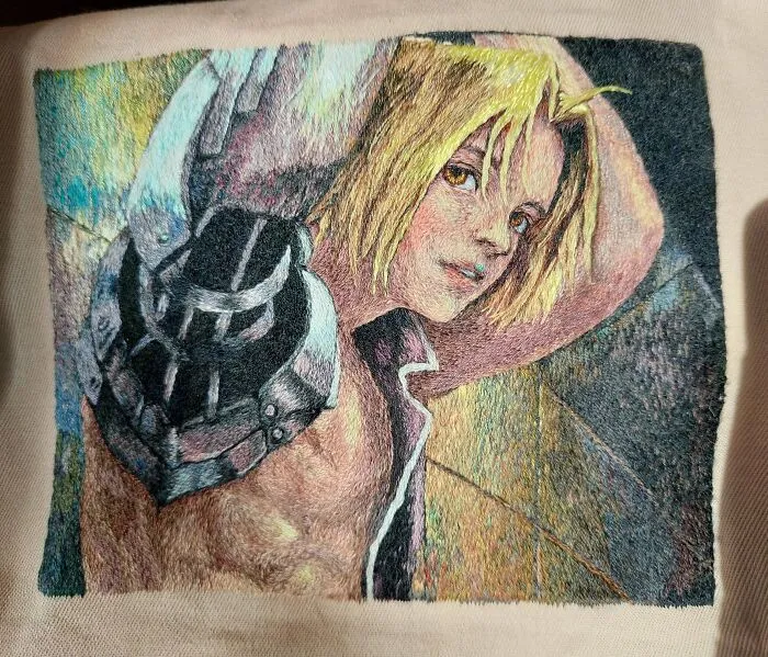 Close-up of a highly detailed hand-embroidered anime character portrait on fabric as an embroidery project