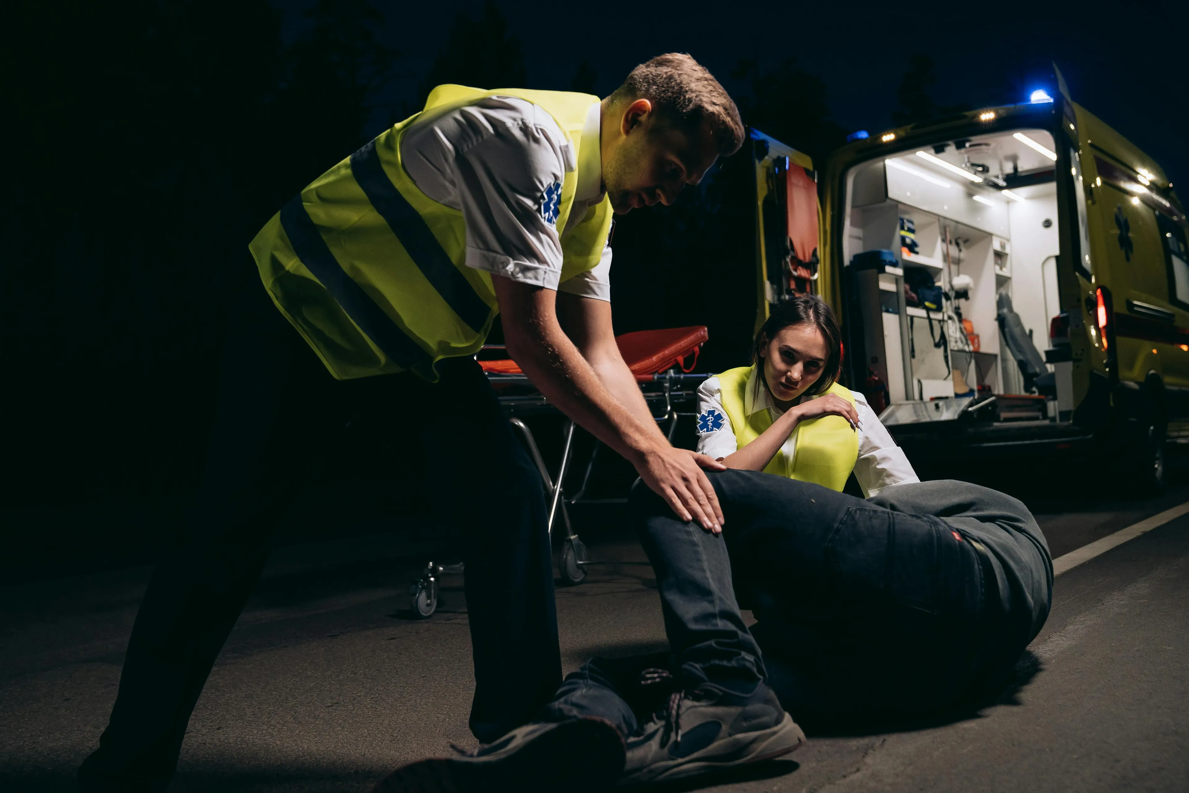 Paramedics assisting a person collapsed on the ground at night. What's your medieval profession? A stranger collapses in front of you.