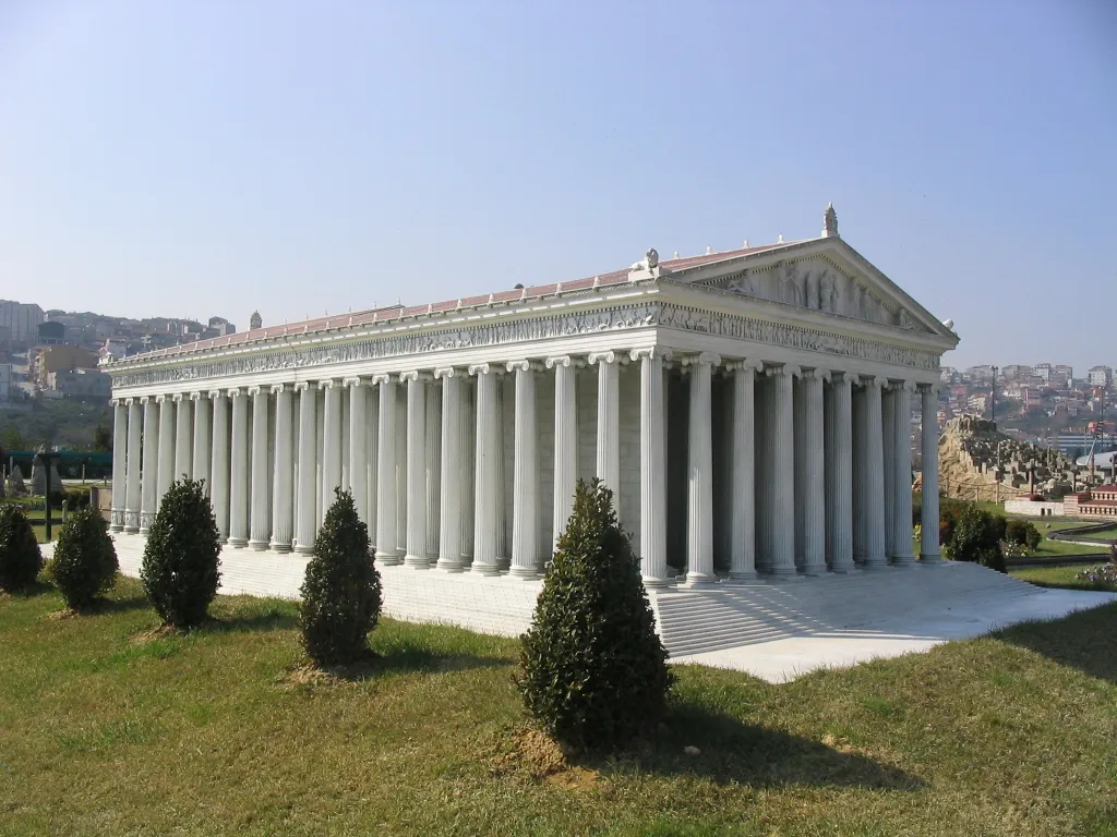 A detailed miniature replica of the Temple of Artemis, featuring numerous white columns and a clear sky backdrop.