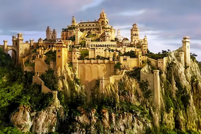 Castle complex from Narnia on a mountain, with multiple levels and towers, surrounded by lush green foliage.