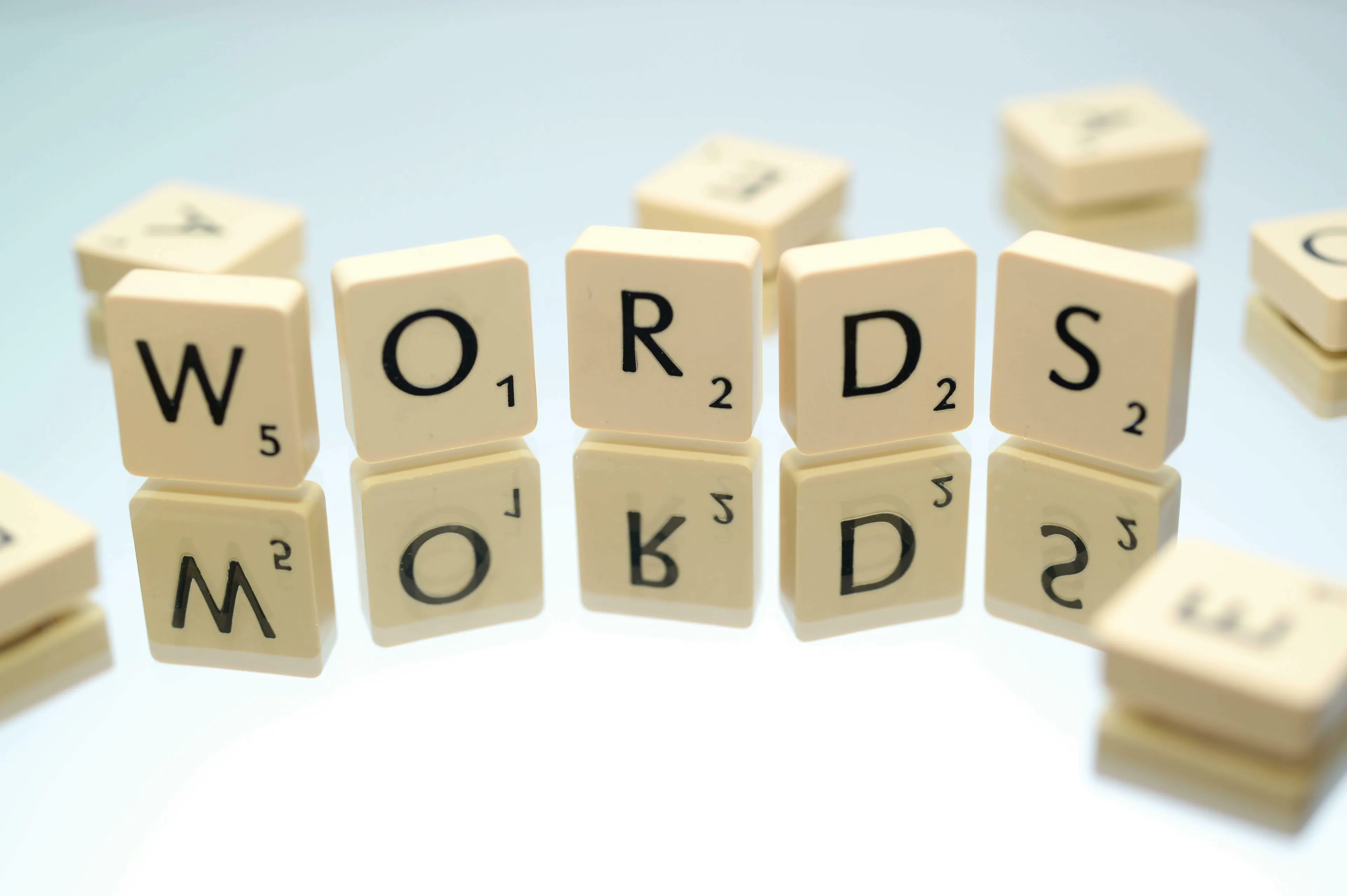 Scrabble tiles spelling WORDS with reflections, perfect for a general knowledge quiz on word origins.