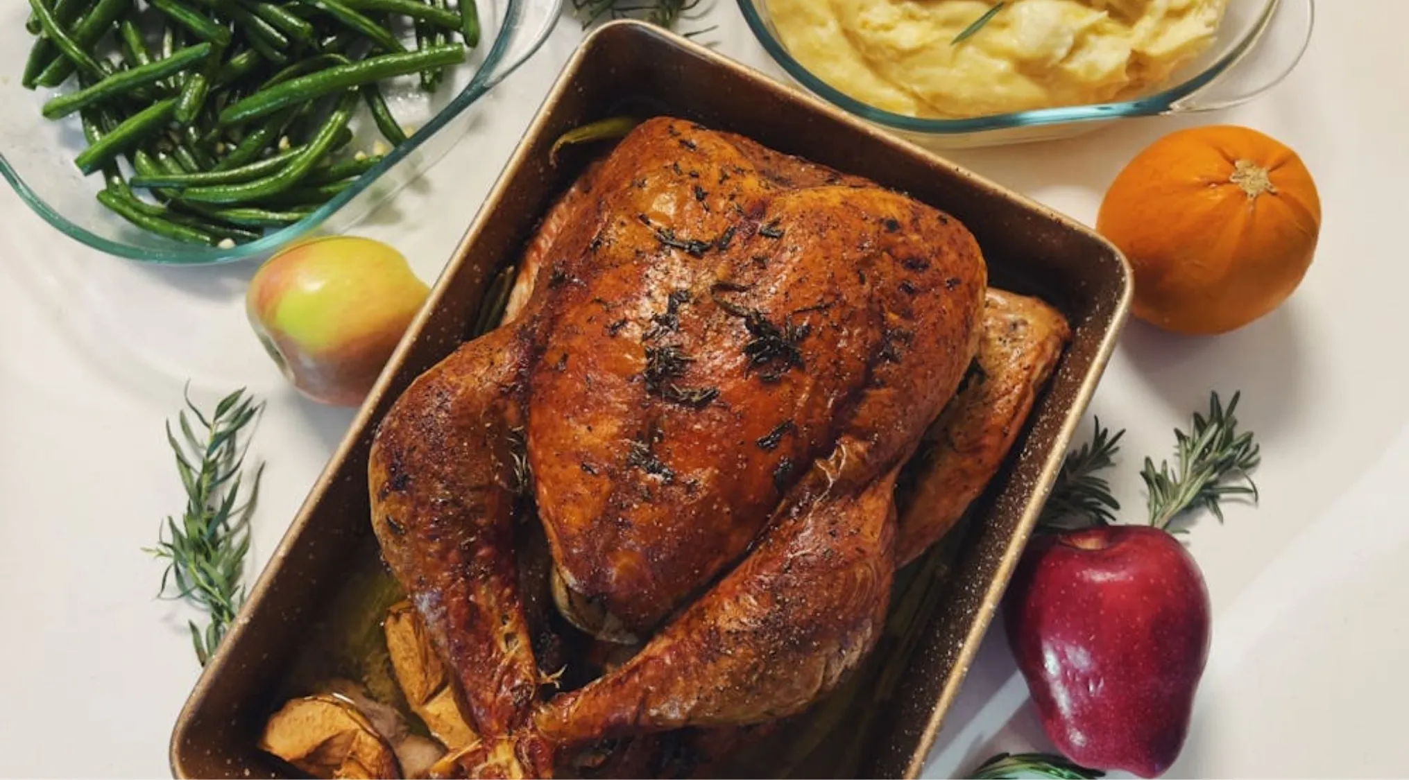 A roasted Thanksgiving turkey with green beans, mashed potatoes, and festive decor, representing celebrations in America.