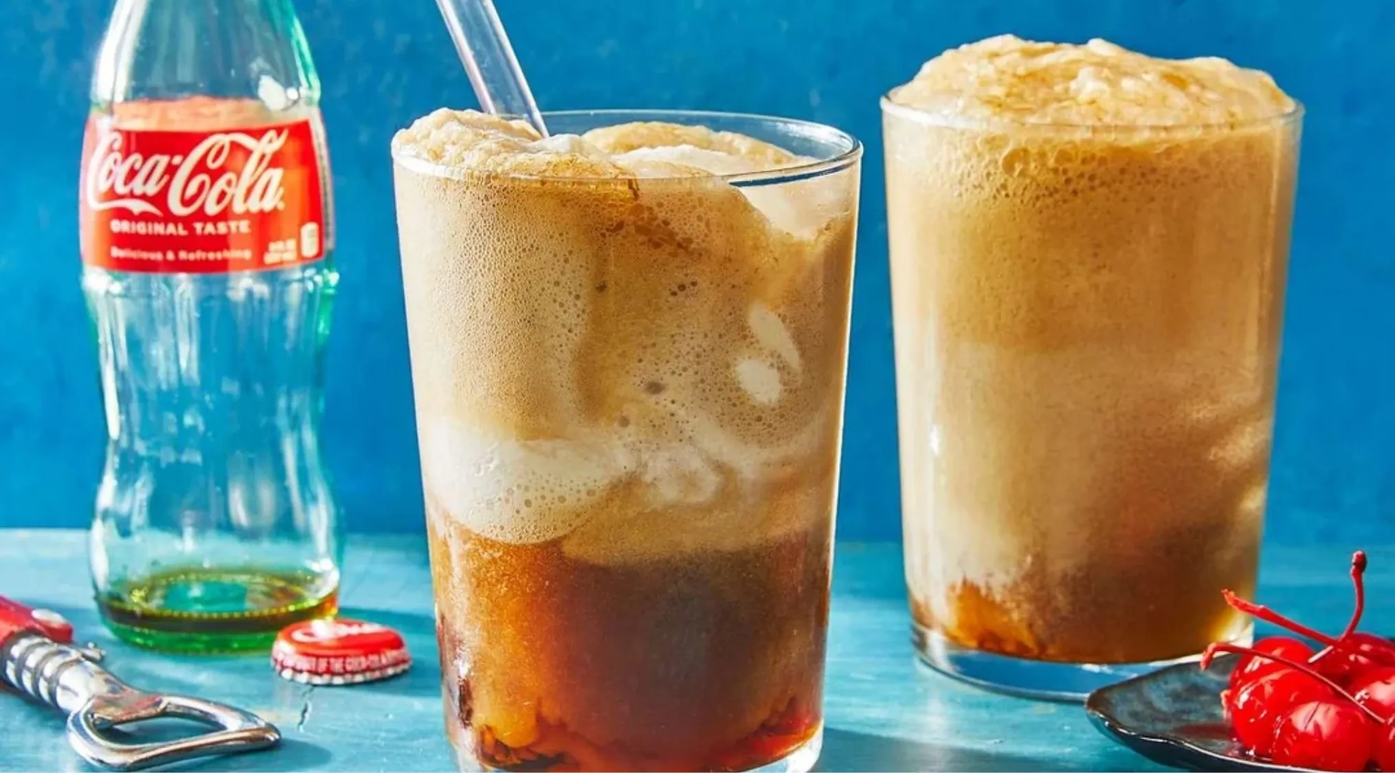 Two tall glasses of soda with scoops of ice cream, showing a classic American drink, next to a Coca-Cola bottle.