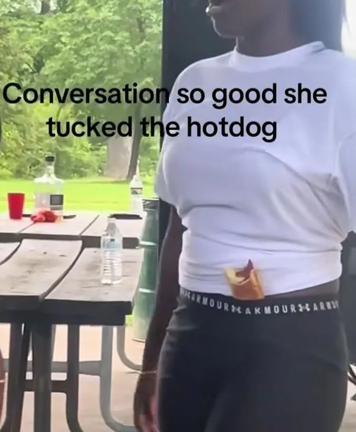 Woman tucking hotdog in waistband with funny humor caption