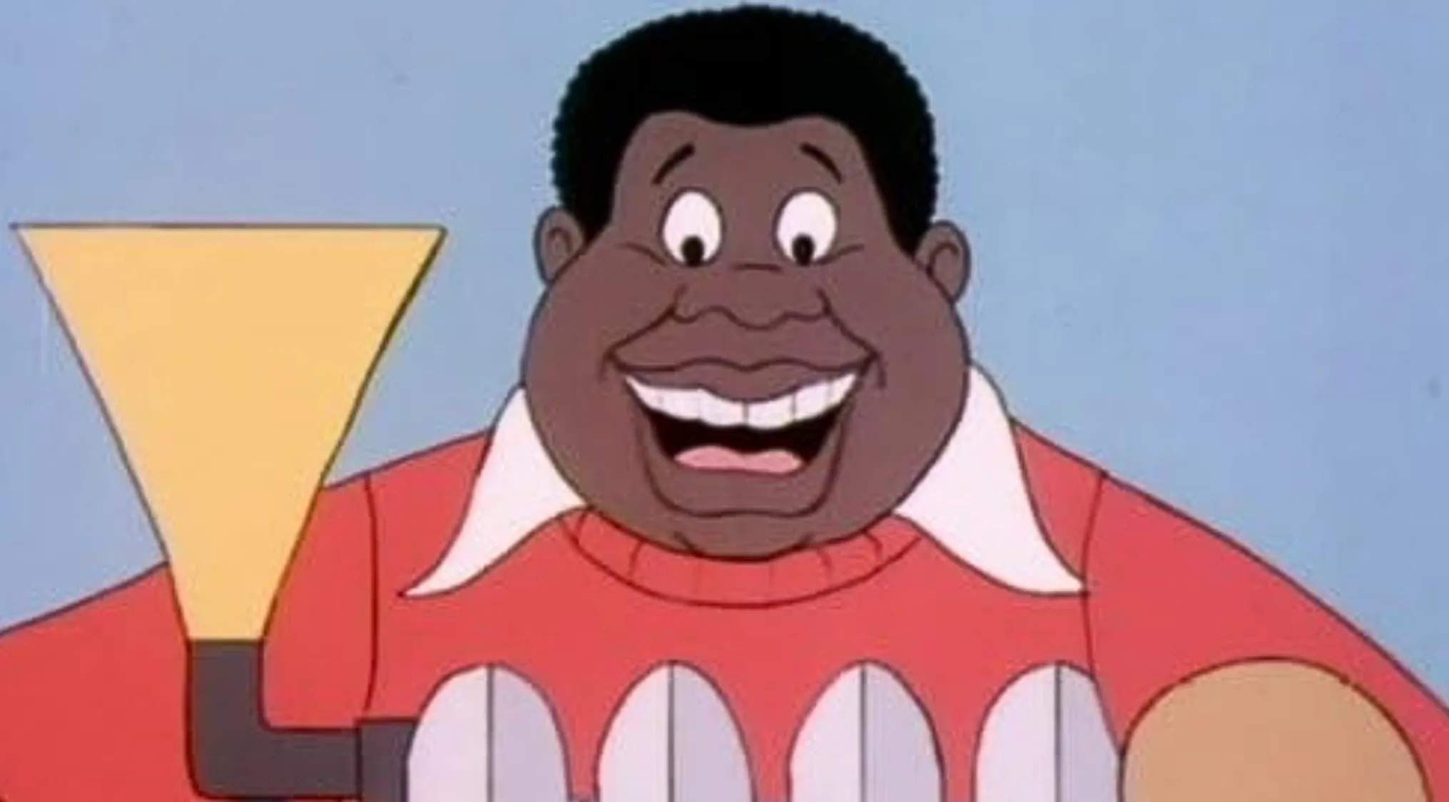 A smiling cartoon character with dark skin and hair, wearing a red shirt with white collar. Saturday Morning Cartoons Trivia.