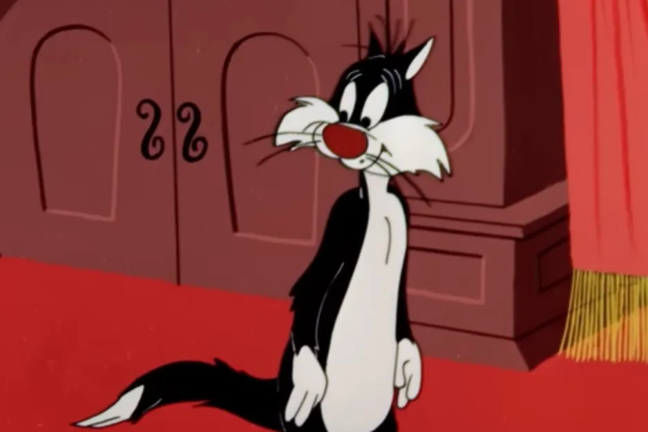 Sylvester the Cat, a cartoon hunter, looking perplexed, standing on a red carpet with a closed brown door in the background.