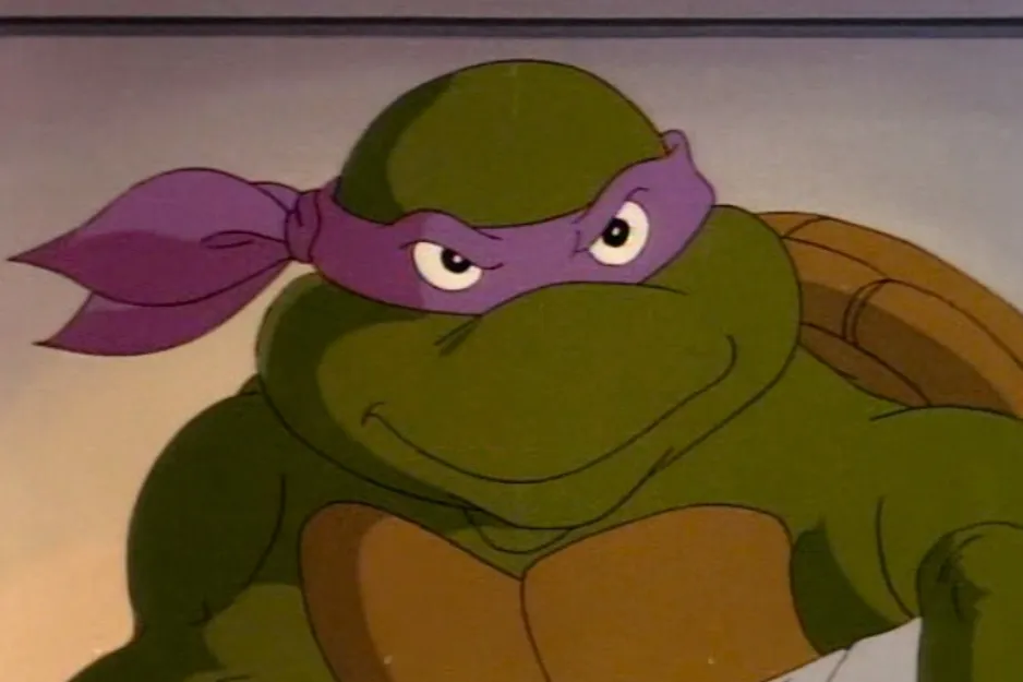 Close-up of a Teenage Mutant Ninja Turtle, likely Michelangelo, wearing a purple mask and a serious expression.