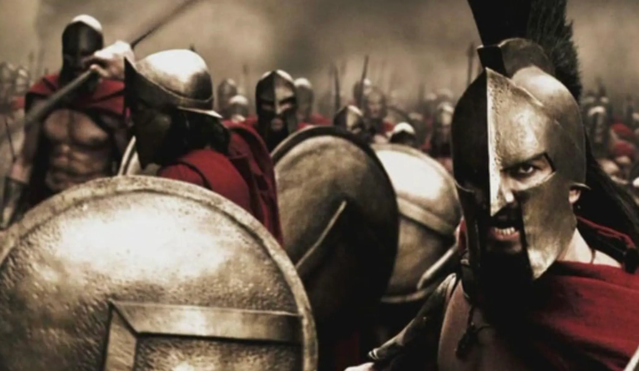 Ancient Greek Spartan warriors in helmets and red cloaks, holding shields. History school questions.