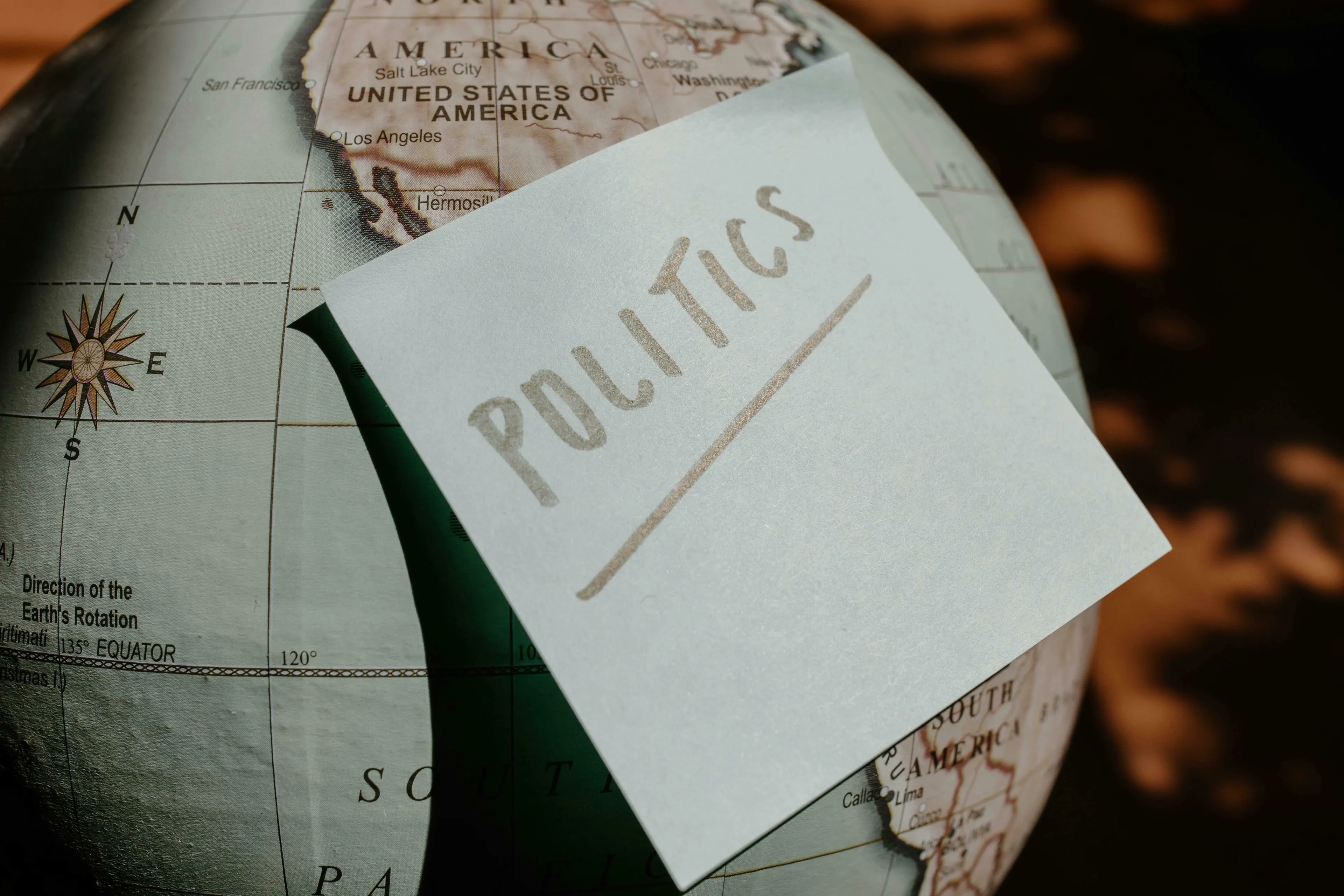 A globe with a sticky note labeled "POLITICS" on it. A General Knowledge quiz question about democracy.