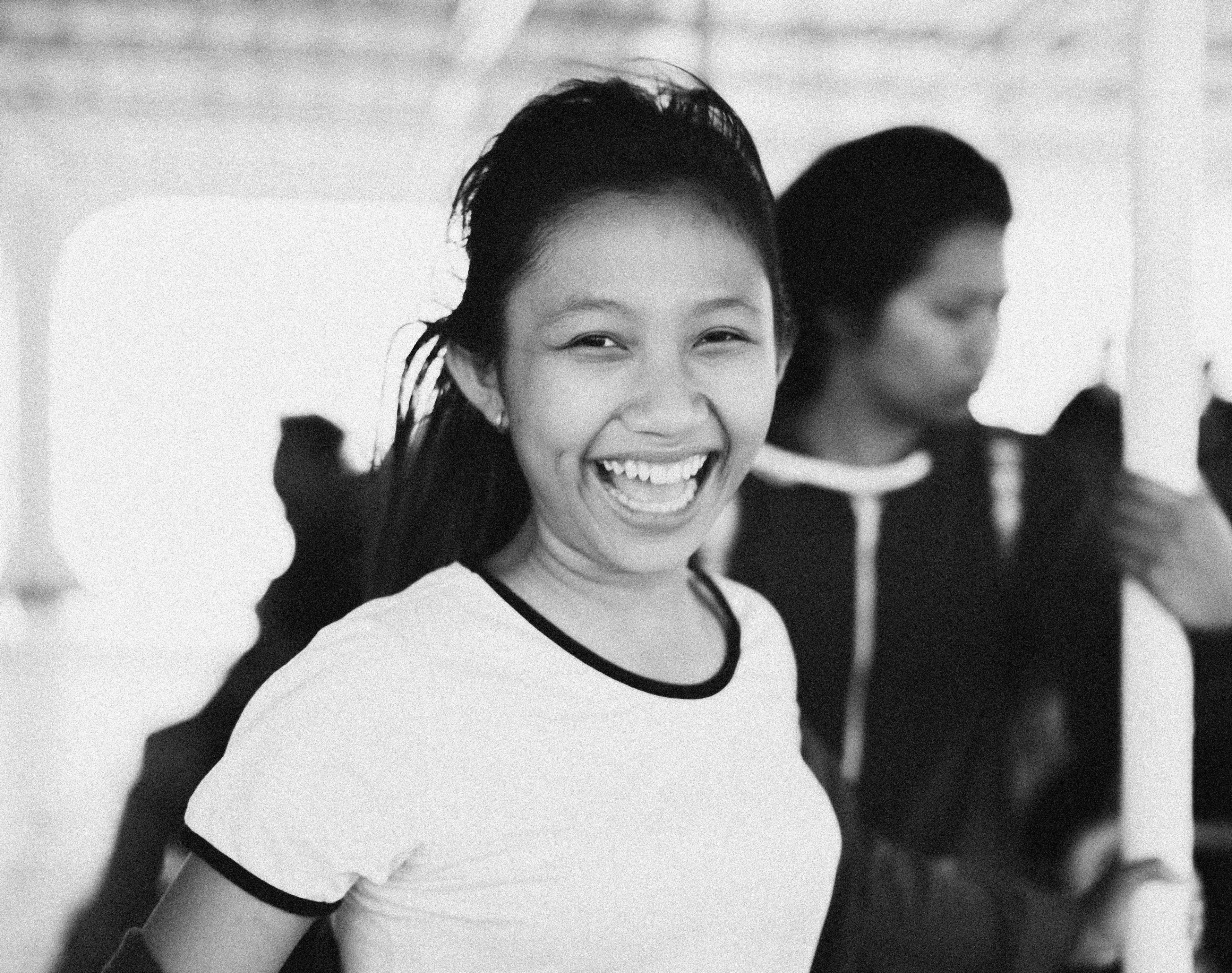 Black and white photo of a smiling woman with a high ponytail, wearing a white shirt. Big Ideas Quiz image.