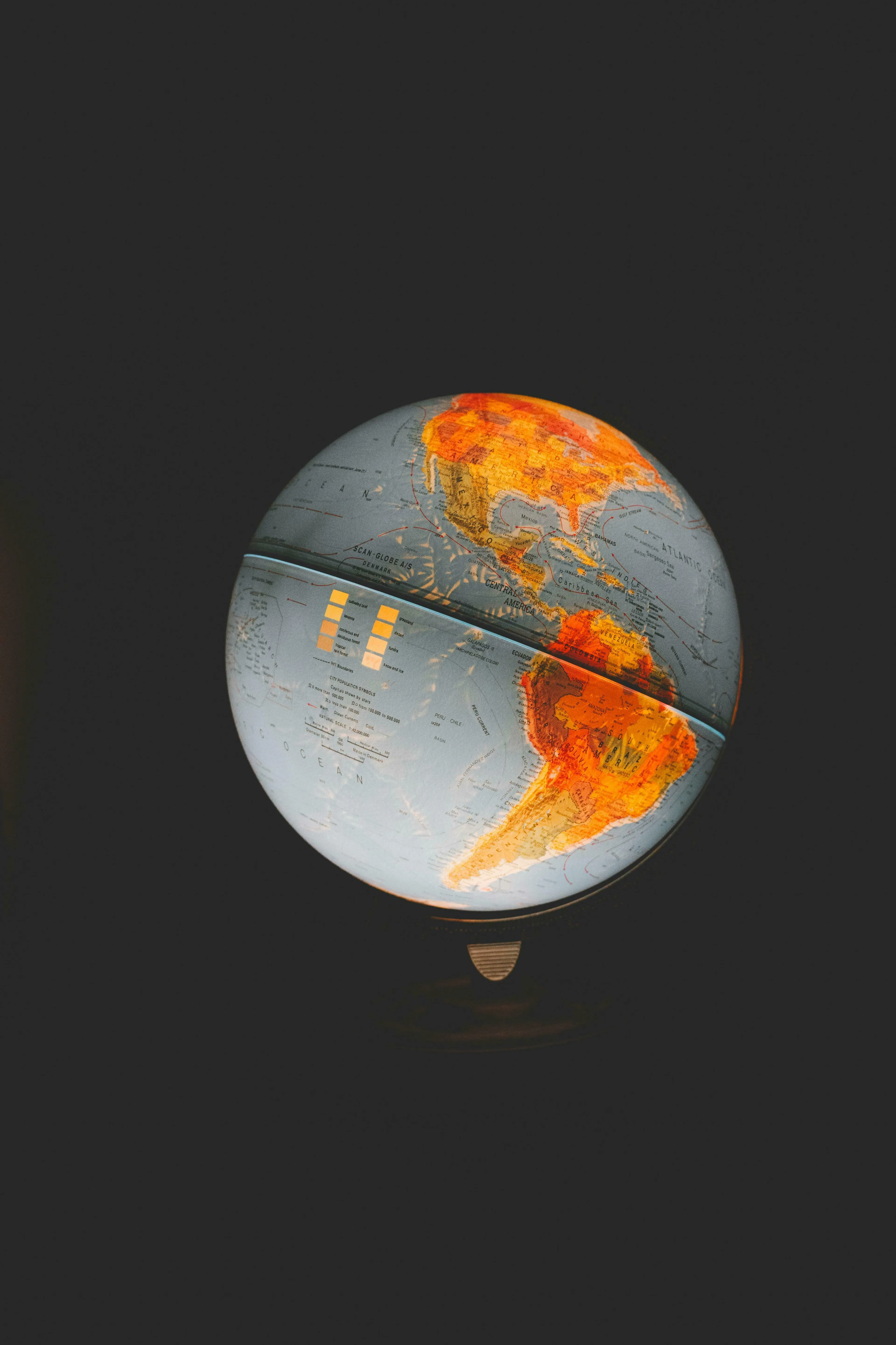 An illuminated globe showing North and South America, highlighted against a dark background, representing general knowledge.