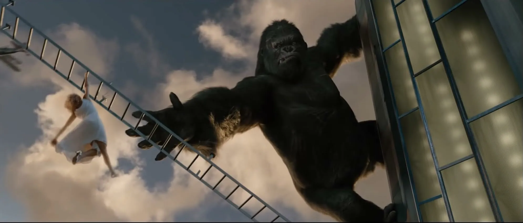 King Kong, the giant ape, climbs the Empire State Building with a woman in white dress on a ladder nearby. General knowledge.