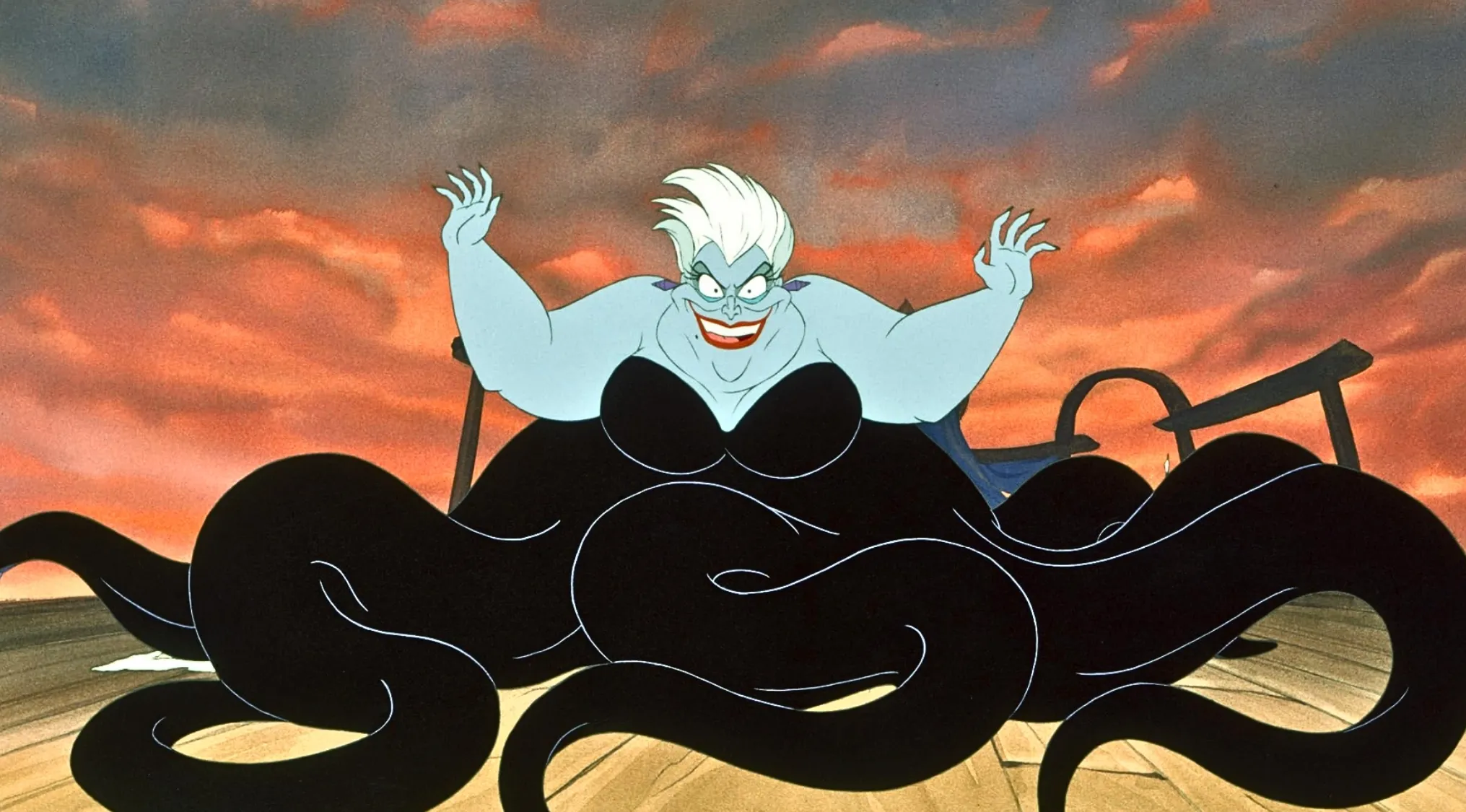Ursula, the fictional sea witch from Disney's The Little Mermaid, with arms raised and a menacing grin. General Knowledge.