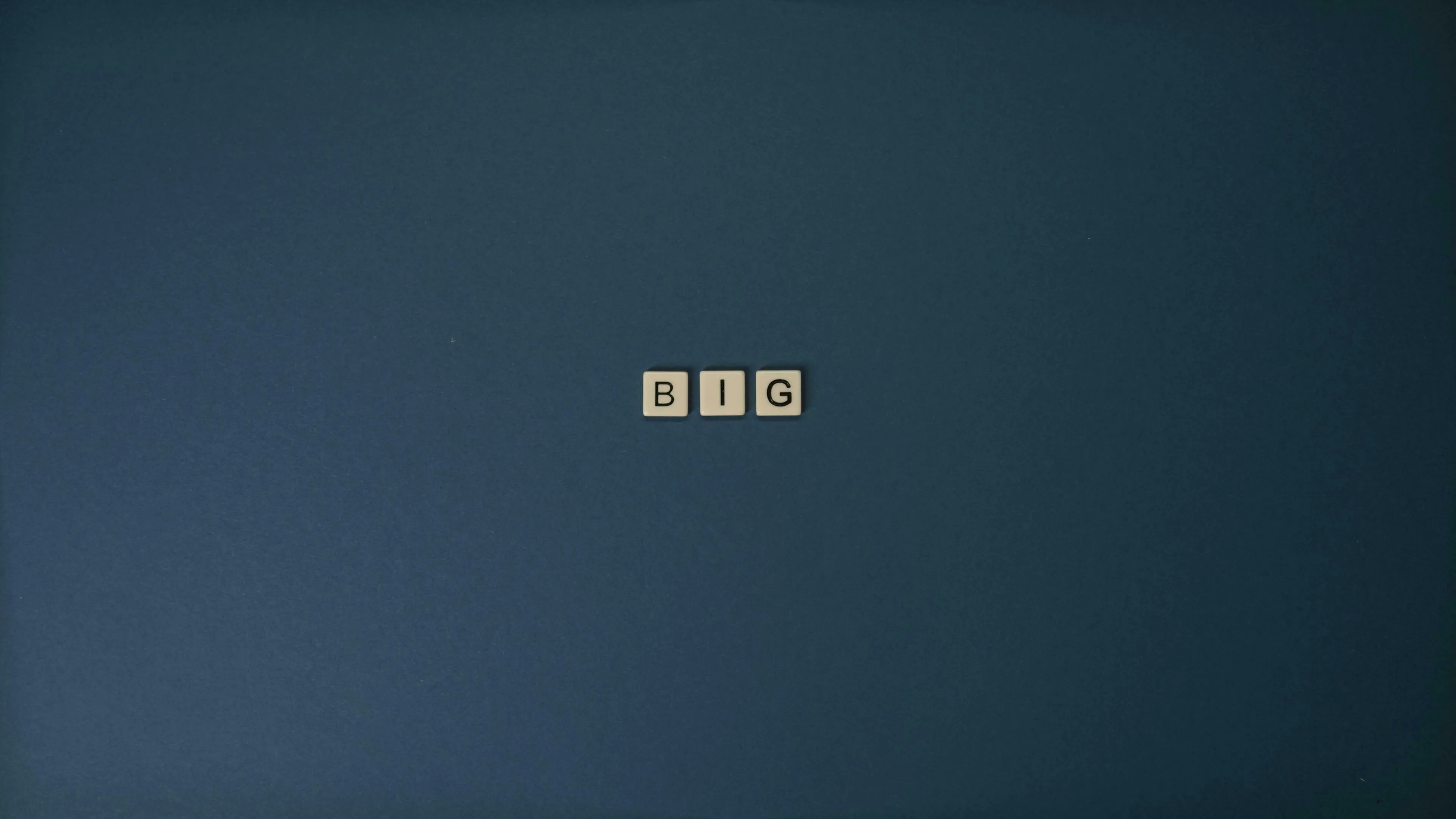 The word BIG spelled out in letter tiles on a plain dark blue background. How do you react to change?