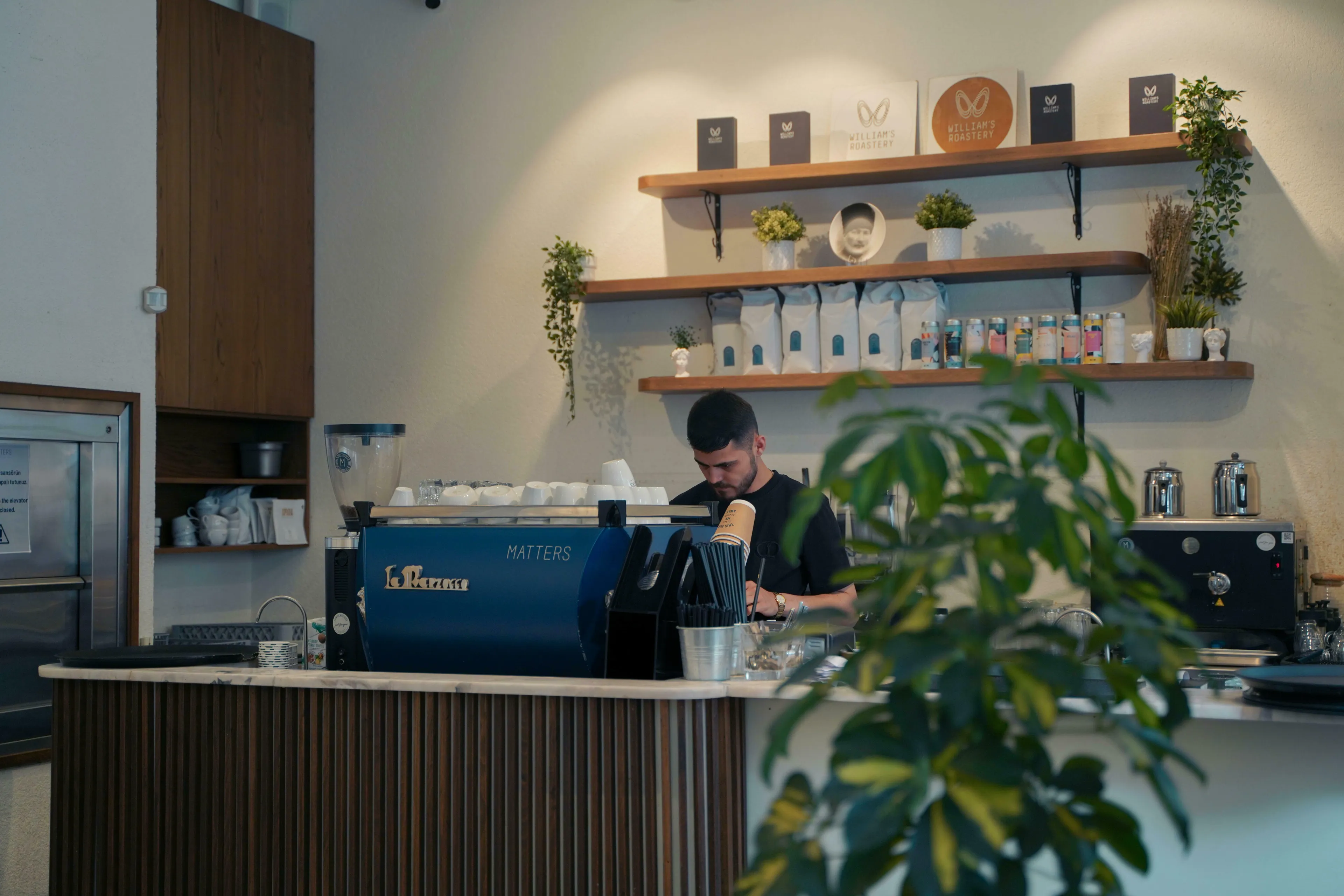 Barista making coffee at a modern coffee shop. React to change, how closure impacts your routine.
