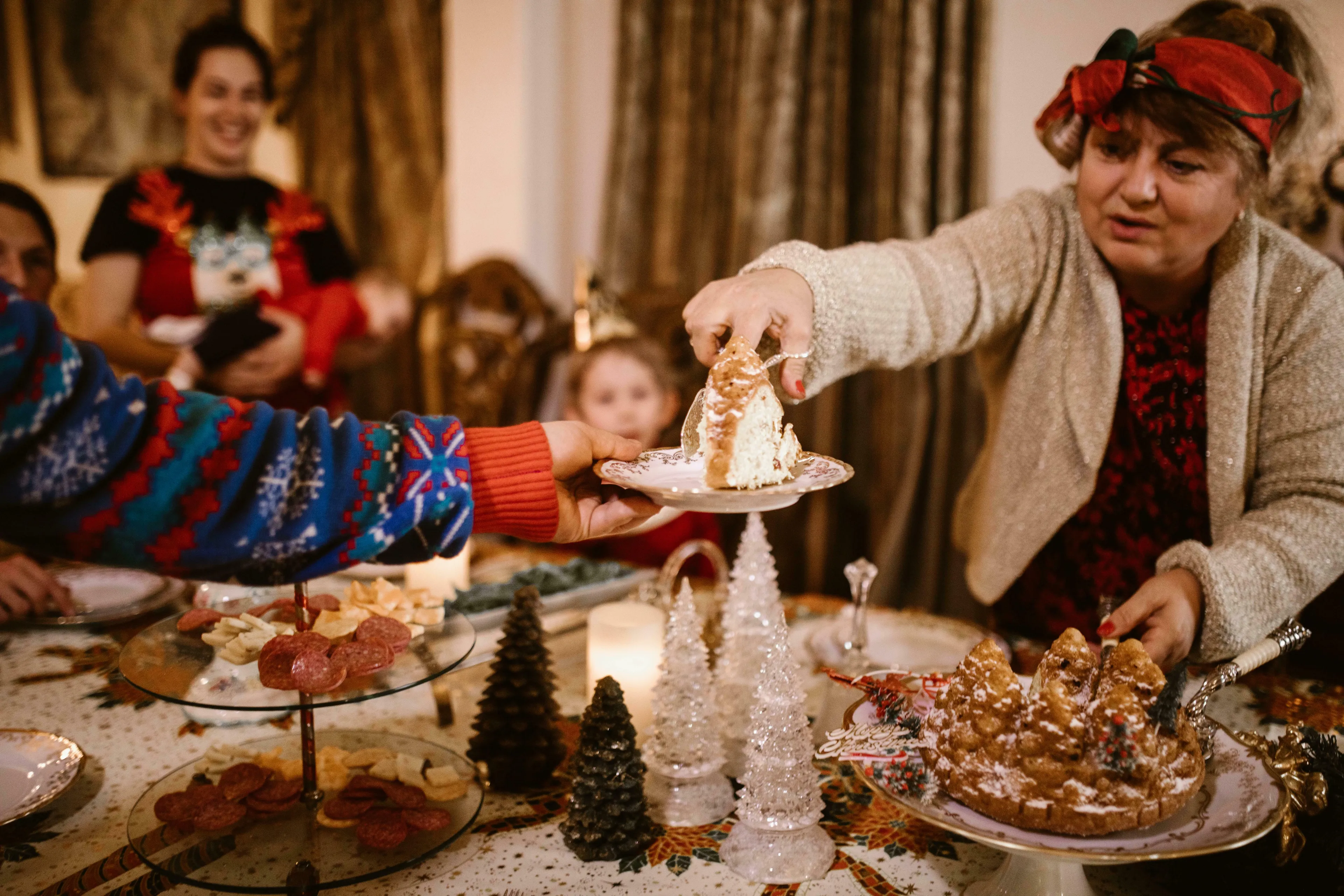 A woman serves cake at a festive family gathering, demonstrating how people react to change in family traditions.