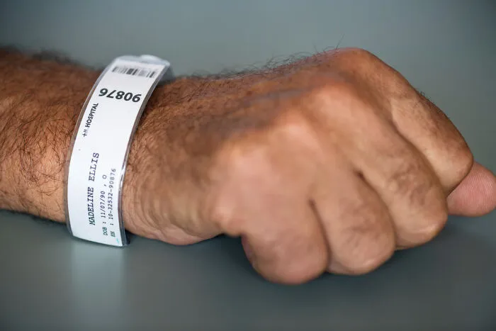 Hospital patient wristband on arm with medical information visible