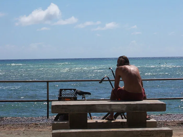 A person sitting on a bench by the ocean, enjoying the view of US states glorified in movies.
