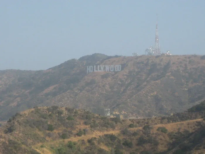 The iconic Hollywood sign on a hill, representing US states glorified in movies.