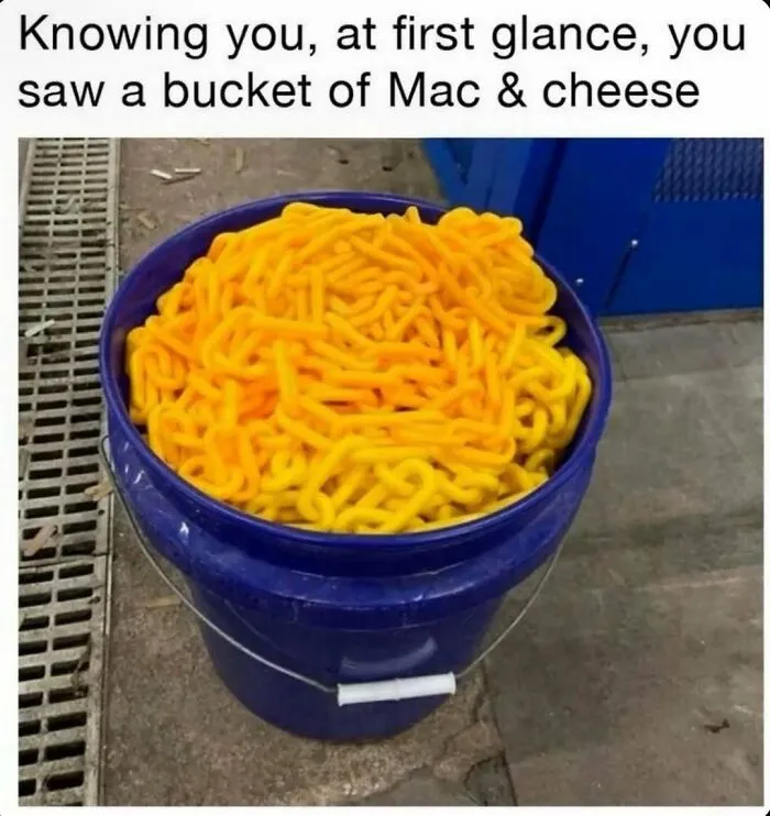 Bucket filled with orange tubed objects resembling mac and cheese food meme