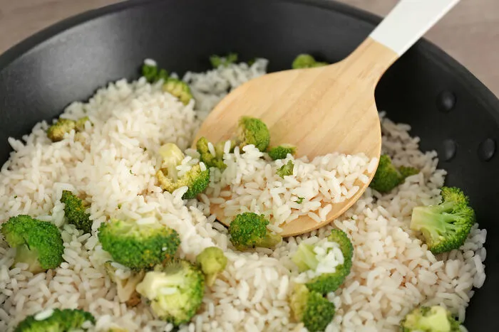 Cooked rice with broccoli in pan for budget poverty meals