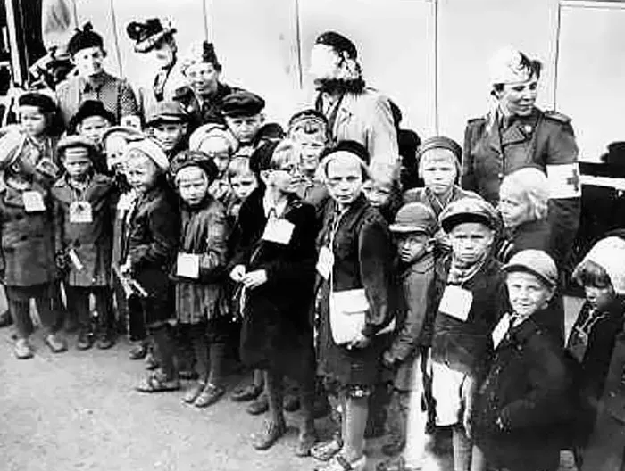 Group of displaced children wearing identification tags during wartime