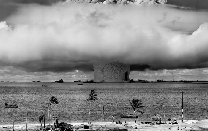 Nuclear bomb test mushroom cloud over ocean in dystopian historical photo