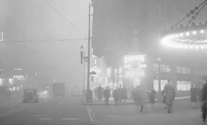 Historic city street engulfed in smog with pedestrians in dystopian photo