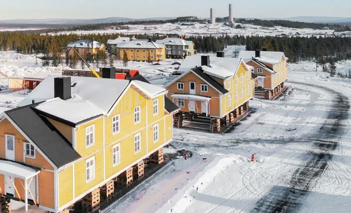 Snow-covered yellow houses elevated in a snowy landscape under cold sky