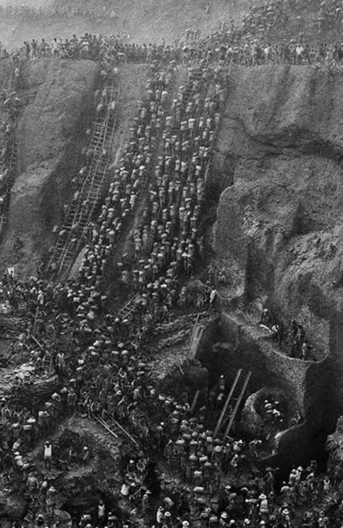 Massive crowd climbing steep rocky slope in historical dystopian scene