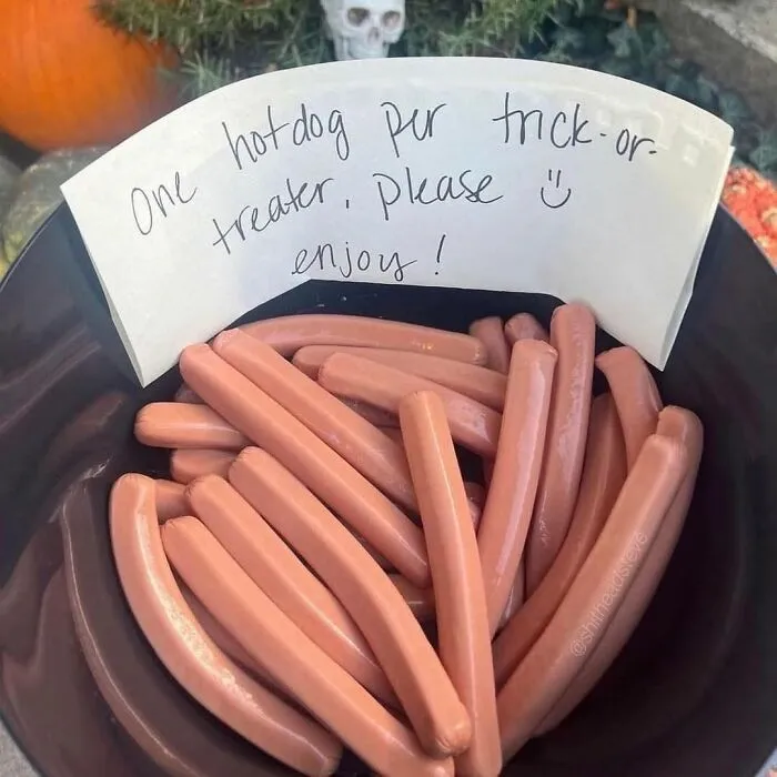 Bowl of hot dogs with a note offering one hot dog per trick-or-treater for Halloween